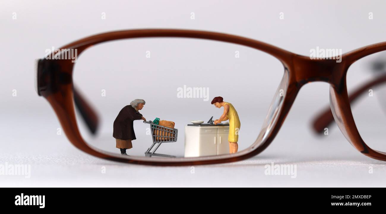 Der Begriff der sozialen Vorurteile gegen Frauen. Brille und Miniaturmenschen. Stockfoto