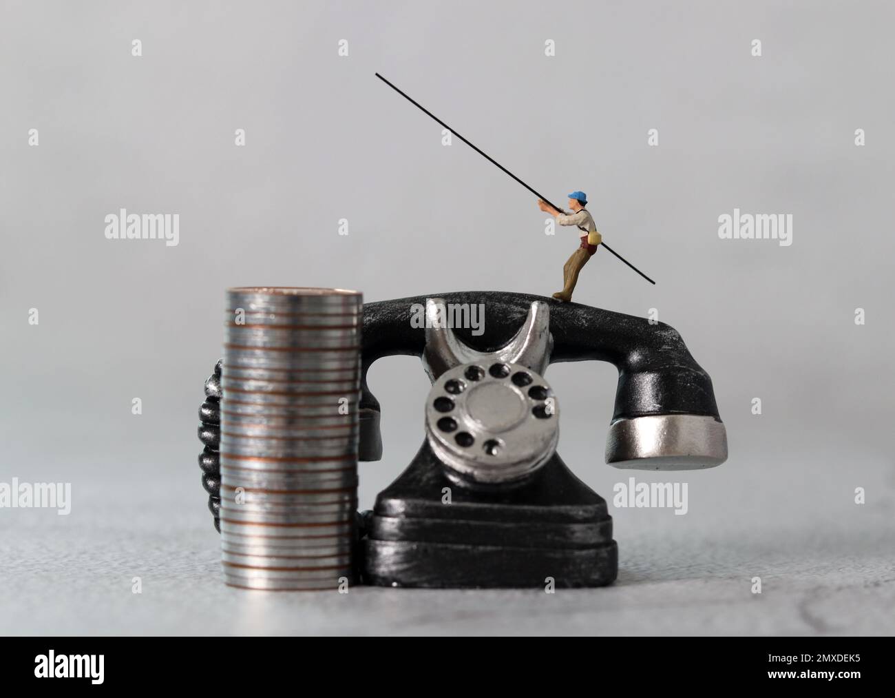 Schwarzes Telefon und Miniaturleute mit Geschäftskonzept. Das Konzept der Warnungen vor Finanzbetrug. Stockfoto