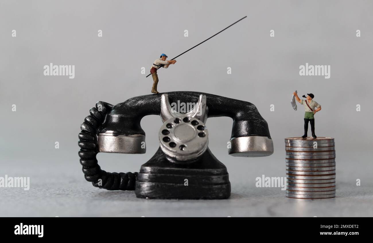 Schwarzes Telefon und Miniaturleute mit Geschäftskonzept. Das Konzept der Warnungen vor Finanzbetrug. Stockfoto