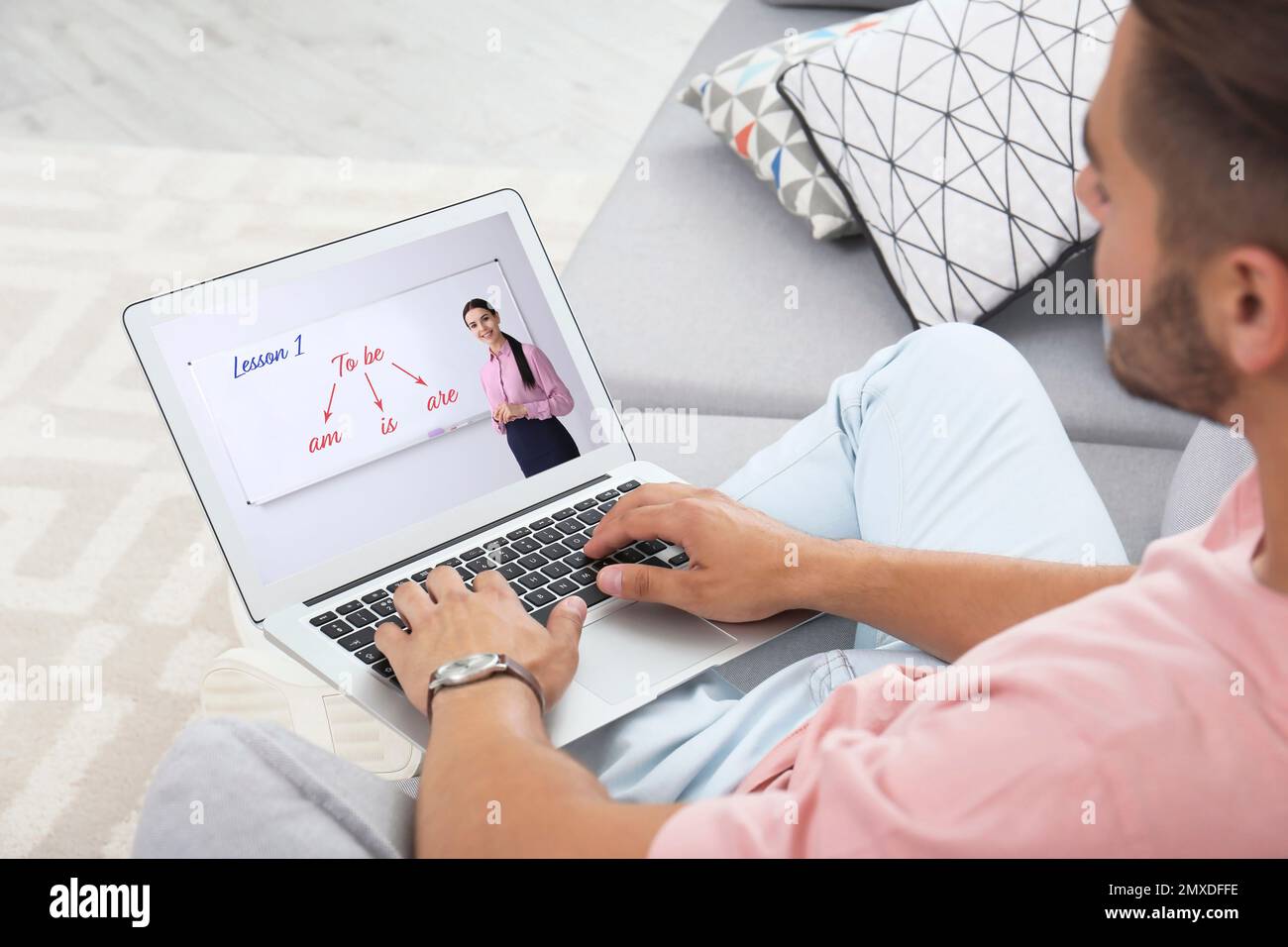 Junger Mann, der ein Notebook für einen Online-Englischunterricht benutzt, mit einem Lehrer zu Hause, Nahaufnahme Stockfoto