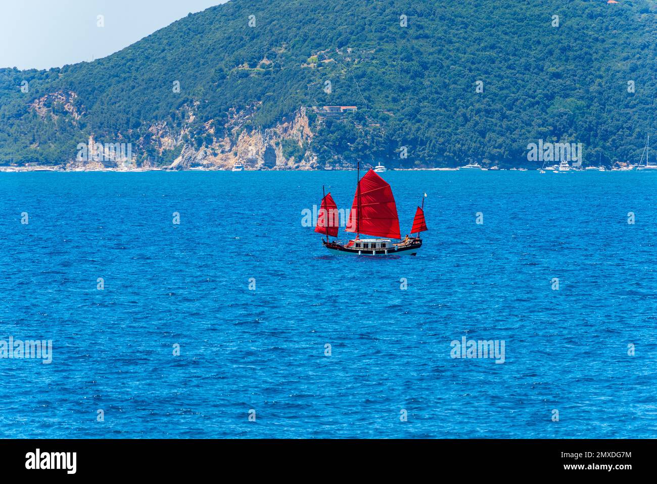 Altes Segelboot mit drei roten Segeln im blauen Mittelmeer vor der Insel Palmaria, Porto Venere, Golf von La Spezia, Ligurien, Italien. Stockfoto