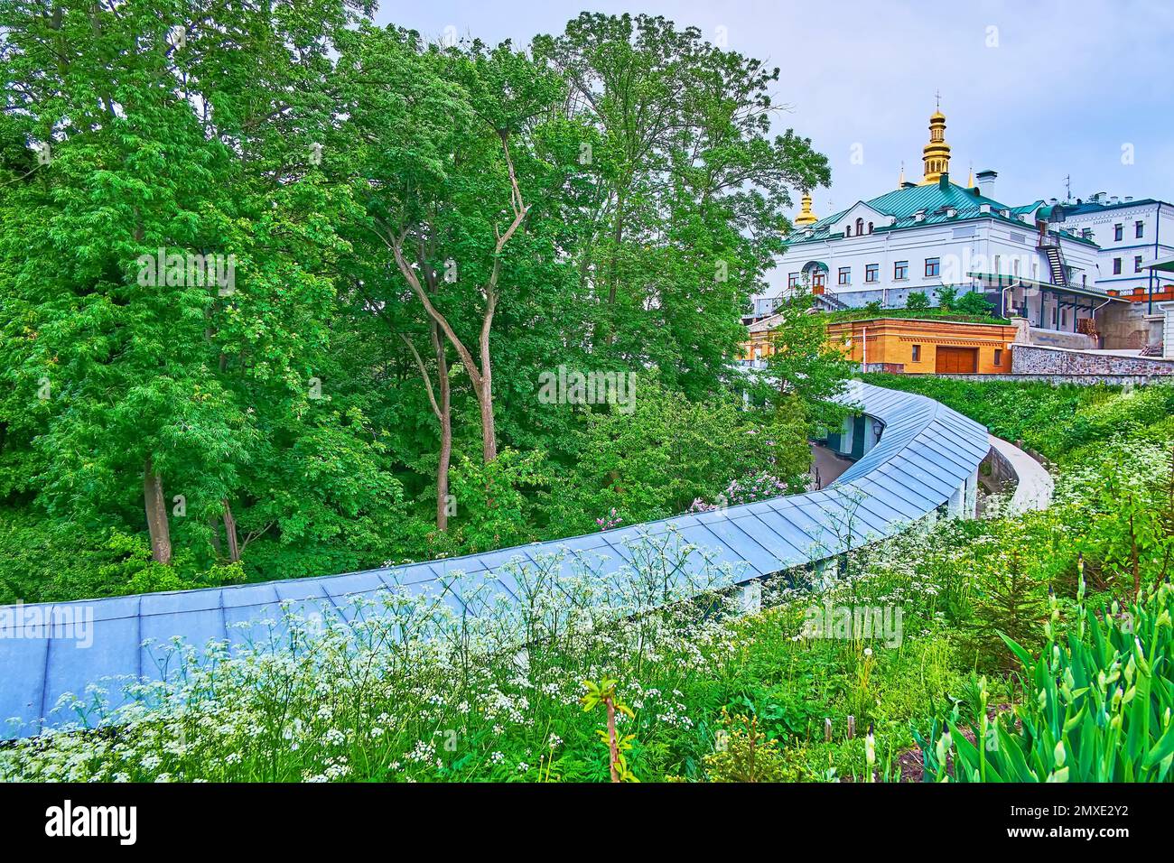 Die überdachte Galerie erstreckt sich entlang des grünen Parks des Klosters Kiew Pechersk Lavra Cave, Ukraine Stockfoto
