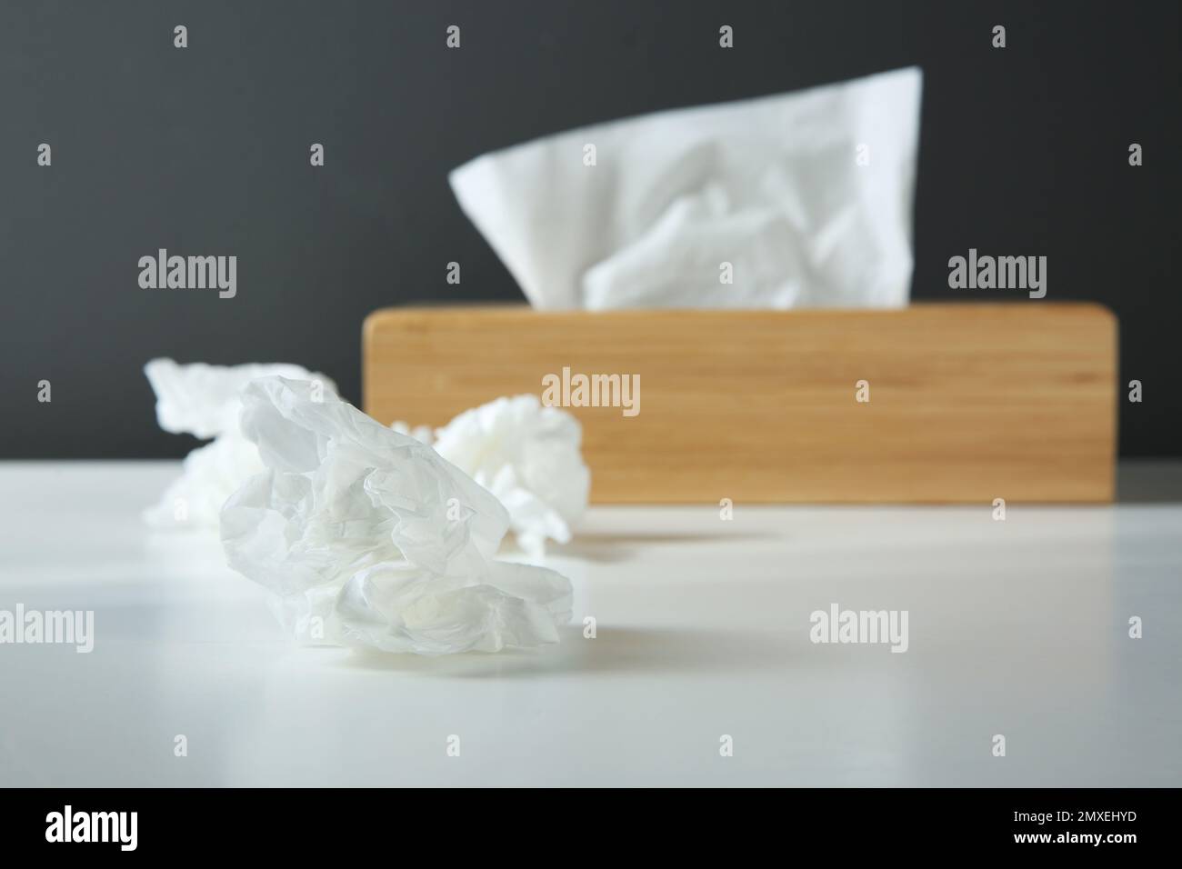 Gebrauchte Papiertücher und Holzhalter auf weißem Tisch Stockfoto