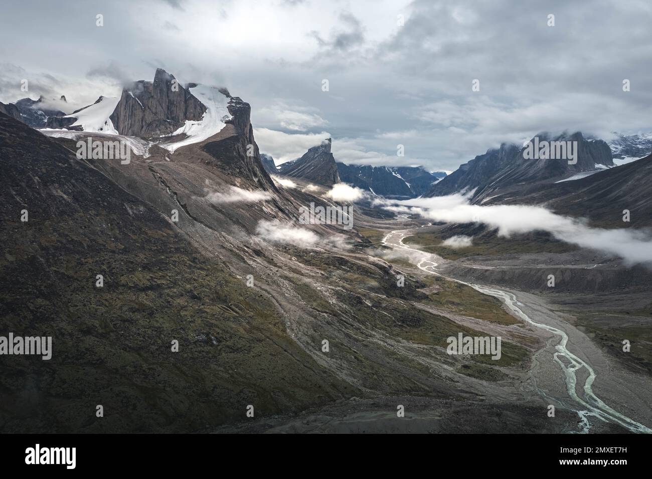 Südwestseite des Mt. Thor, die höchste vertikale Klippe der Erde, an einem bewölkten Septembertag. Wandern im wilden, abgelegenen arktischen Tal des Akshayuk Pass, Baffin Stockfoto