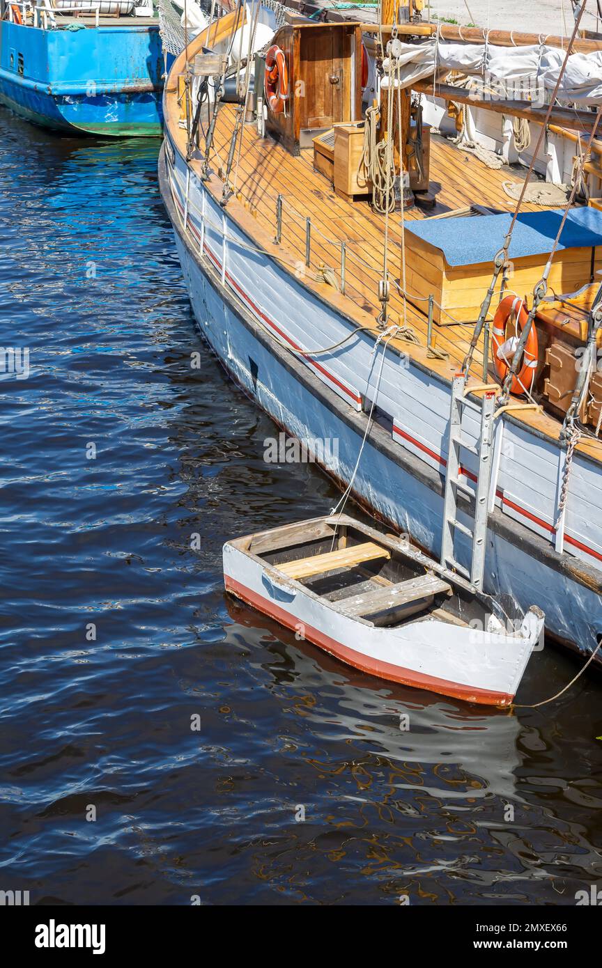 Historisches Segelboot im Hafen mit kleinem Ruderboot Stockfoto