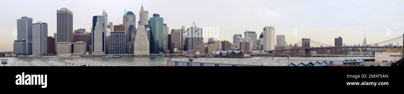 Winterdämmerung in NYC: Ein atemberaubendes Panoramafoto fängt die berühmte Skyline der Stadt ein, die von Abendlichtern, kaltem Wetter und Wolkenschnuppen getaucht ist Stockfoto