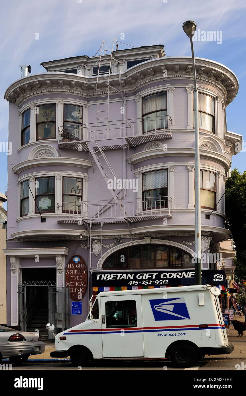 Eckgebäude im viktorianischen Lavendelstil mit Erkerfenstern und einem USPS-Truck, der vor einem tibetischen Souvenirladen in San Franciscos Viertel Haight geparkt ist Stockfoto