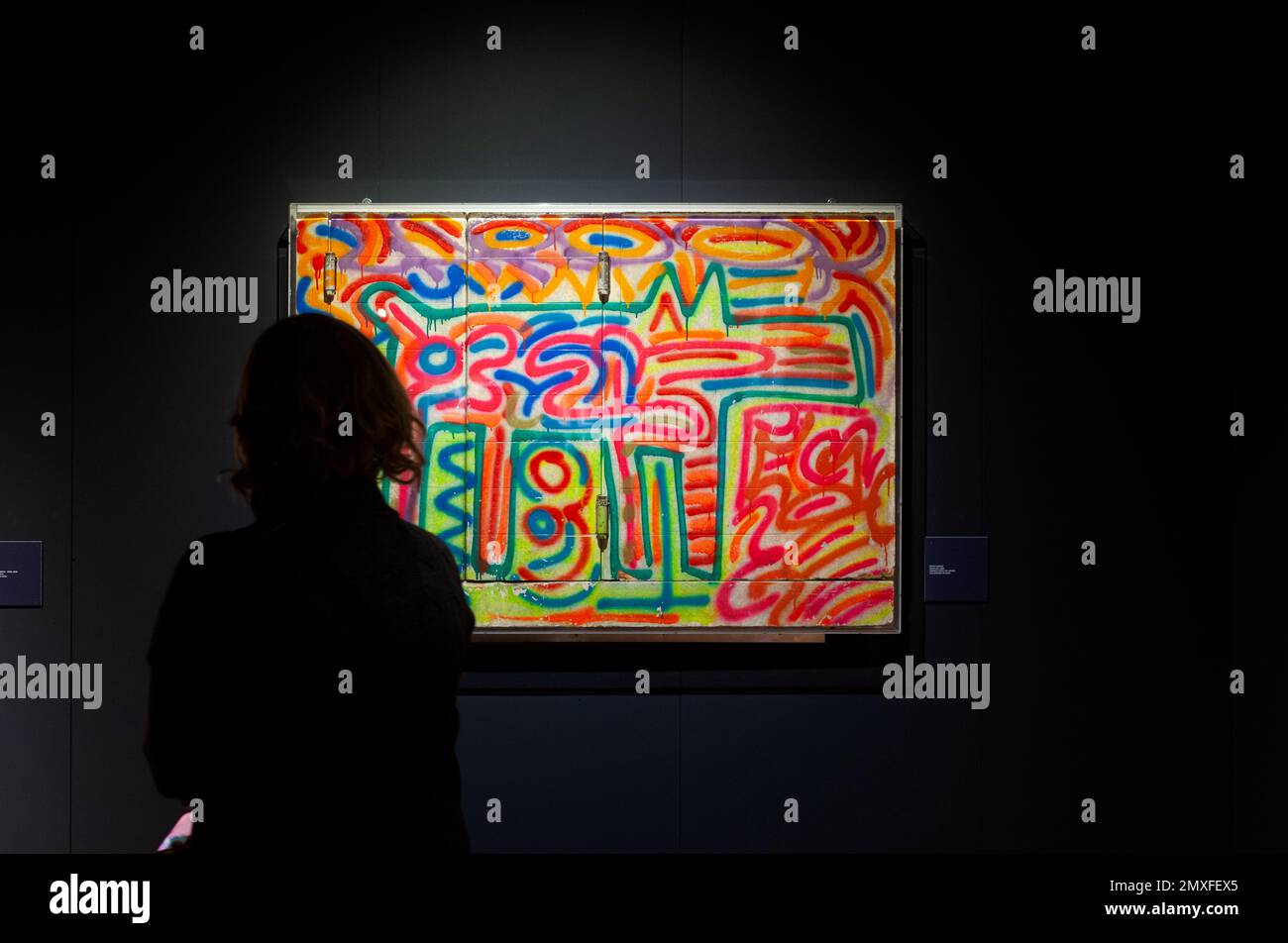 Triest, Italien - 21. Januar 2023: Woman Viewing the Keith Haring Artwork, Untitled, 1983. Sprühen Sie Farbe auf Holz. Ausstellung mit dem Titel "The Great Communicat" Stockfoto