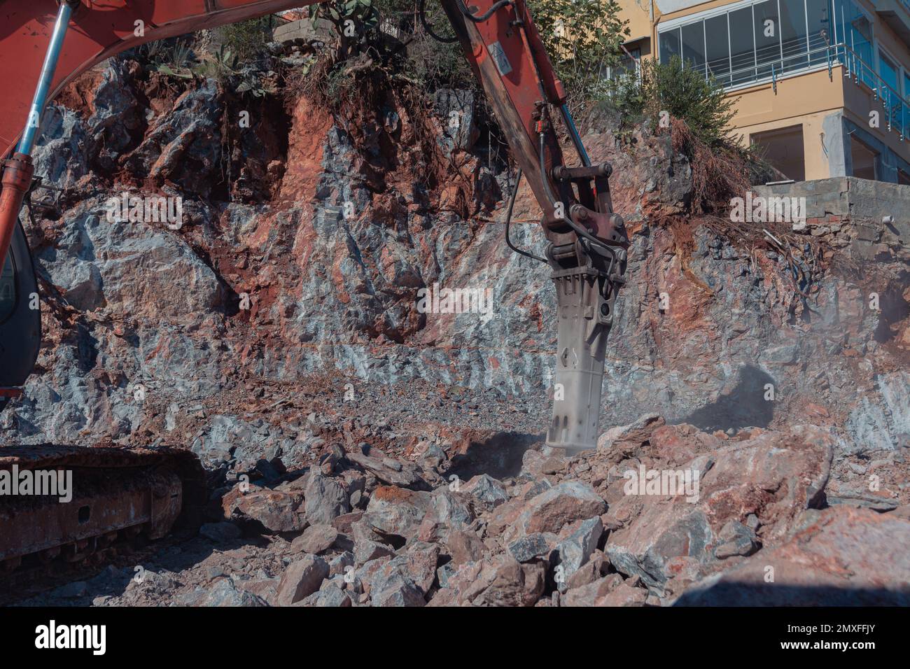 Schwere Maschinenarbeiten auf der Baustelle. Rodung von steinigem Boden für den Bau in der Türkei. Der Bagger zerquetscht das Gestein. Stockfoto