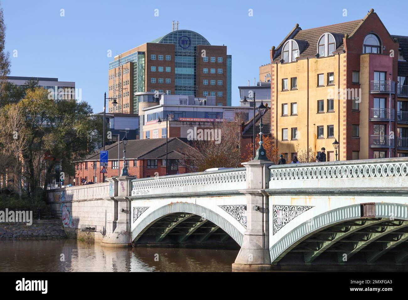 Sonniger Herbsttag im Stadtbild von Belfast und seitlicher Blick auf die Albert Bridge, die sich über die Gebäude des Flusses Lagan und die Skyline von Belfast im Hintergrund erstreckt. Stockfoto