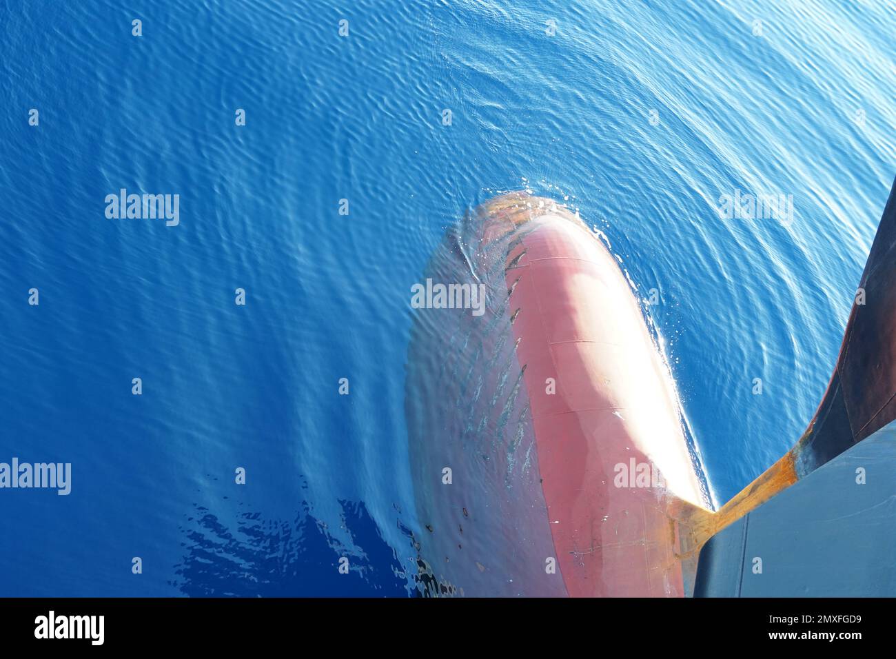 Blick auf den teilweise untergetauchten roten Bug auf einem Containerfrachtschiff, das für schwere Lasten ausgelegt ist. Stockfoto