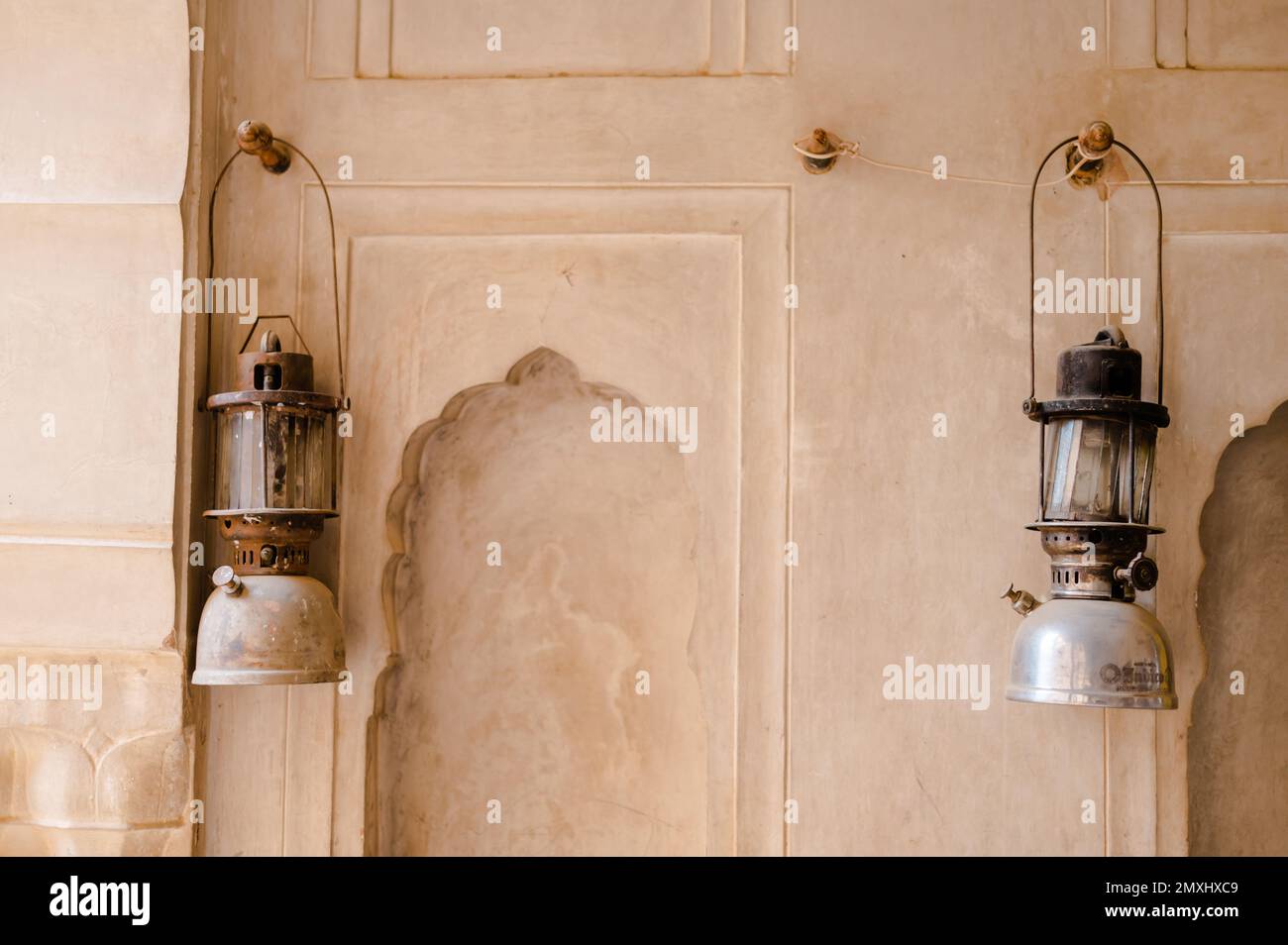 Eine malerische Aufnahme der beiden unter Druck stehenden Paraffinlampen hing an einer Wand Stockfoto