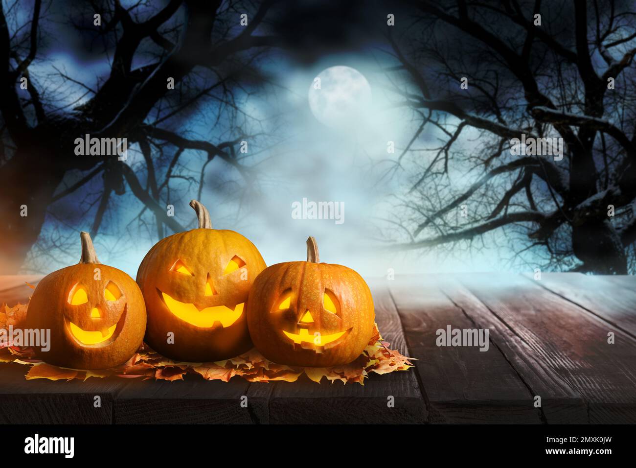 Unheimliche Jack O Lantern Kürbisse umgeben von mystischem Nebel bei Vollmond an Halloween. Platz für Text Stockfoto