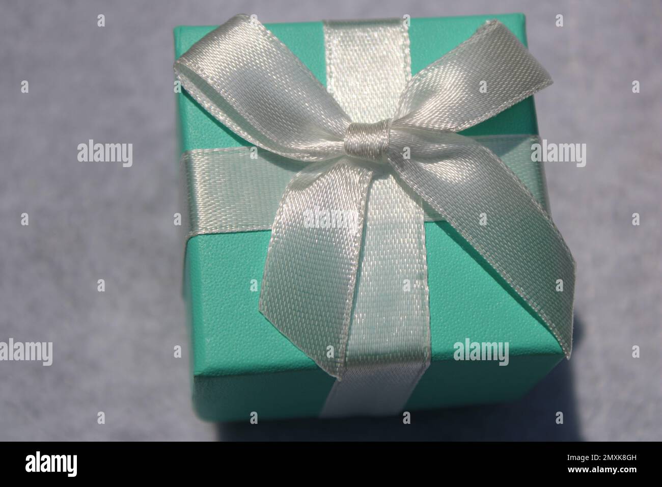 Nahaufnahme einer grünen Geschenkbox aus Seeschaum mit weißer Schleife Stockfoto