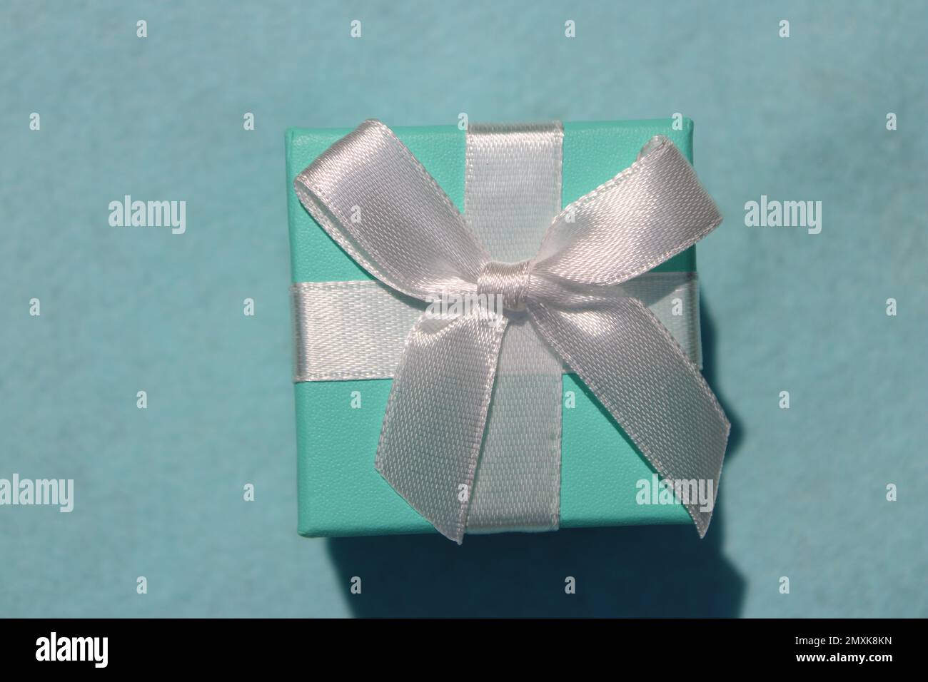 Nahaufnahme einer grünen Geschenkbox aus Seeschaum mit weißer Schleife Stockfoto