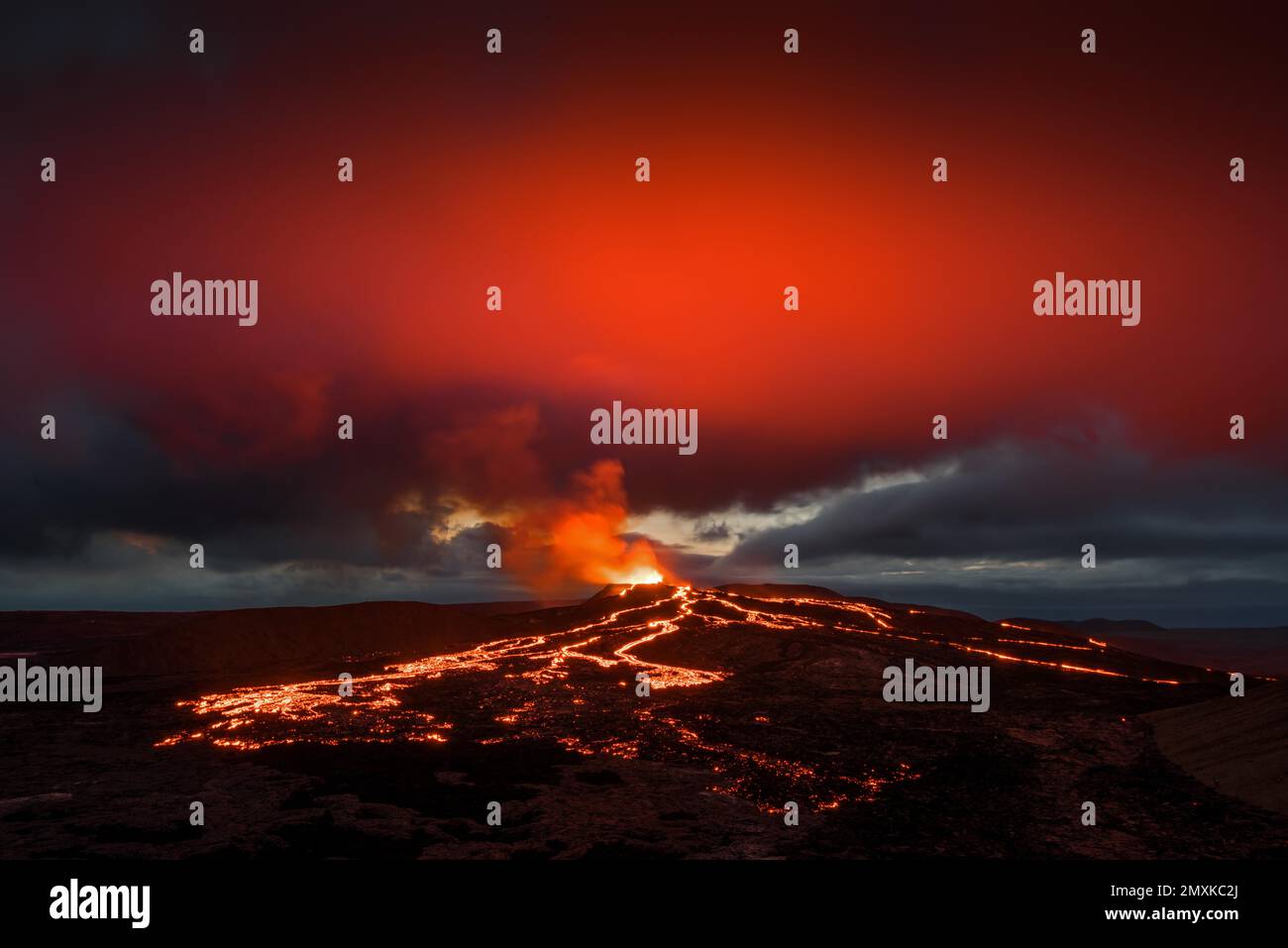 Lava, die aus dem Krater spritzt und rötliche Reflexionen auf der Wolke, Lavaströme, Vulkan ausbricht, Tafelvulkan Fagradalsfjall, Vulkansystem Krýsuvík, Reyk Stockfoto