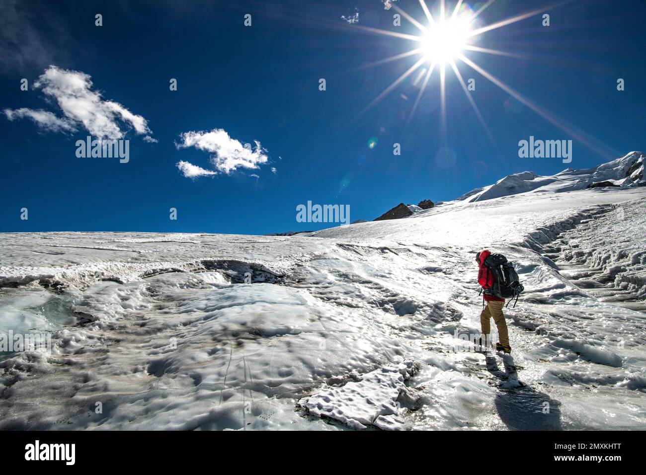Ein Kletterer mit Steigeisen und Rucksack geht über den sonnenbeleuchteten Mera-Gletscher, Mera Peak 6476 m, Khumbu Region, Himalaya, Nepal, Asien Stockfoto