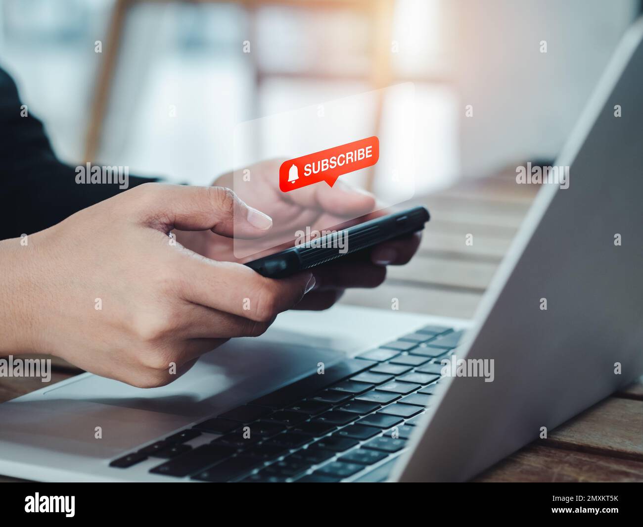 Abonnementkonzept. Die rote Anmeldetaste mit dem Glockensymbol wird auf dem Smartphone in den Händen angezeigt. Horizontaler Smartphone-Stil, der von einer Geschäftsfrau gehalten wird Stockfoto