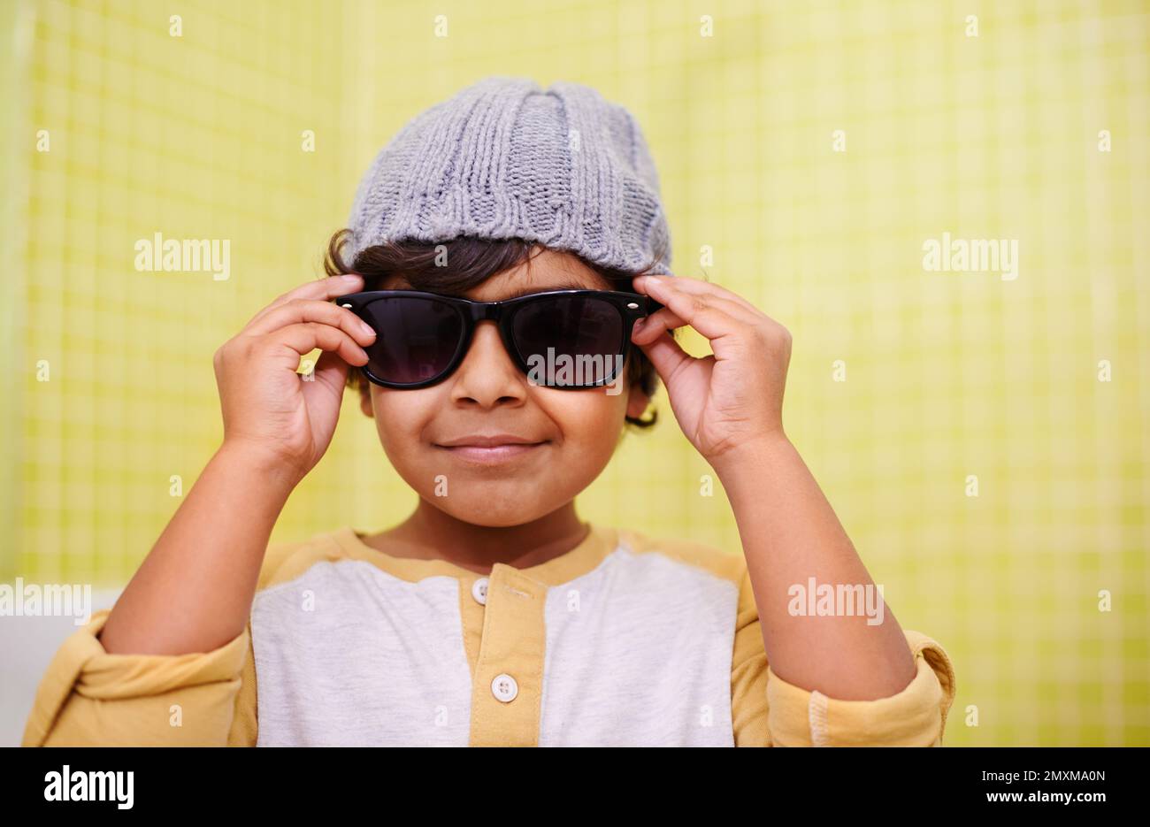 Er ist ein cooler Typ. Porträt eines süßen kleinen Jungen mit Sonnenbrille und Mütze. Stockfoto