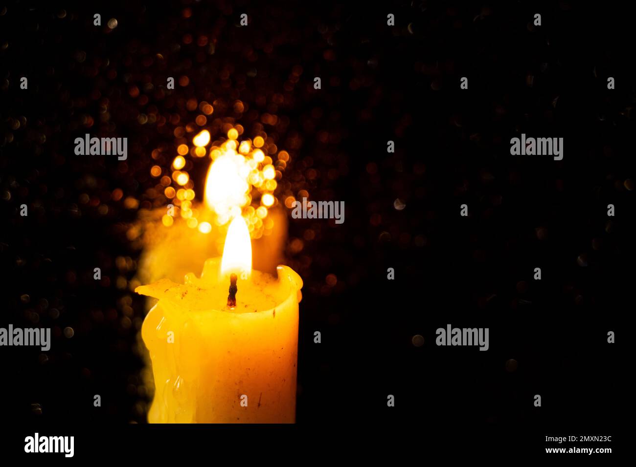 Die Flamme einer Kirchenkerze in einem dunklen Raum Stockfoto