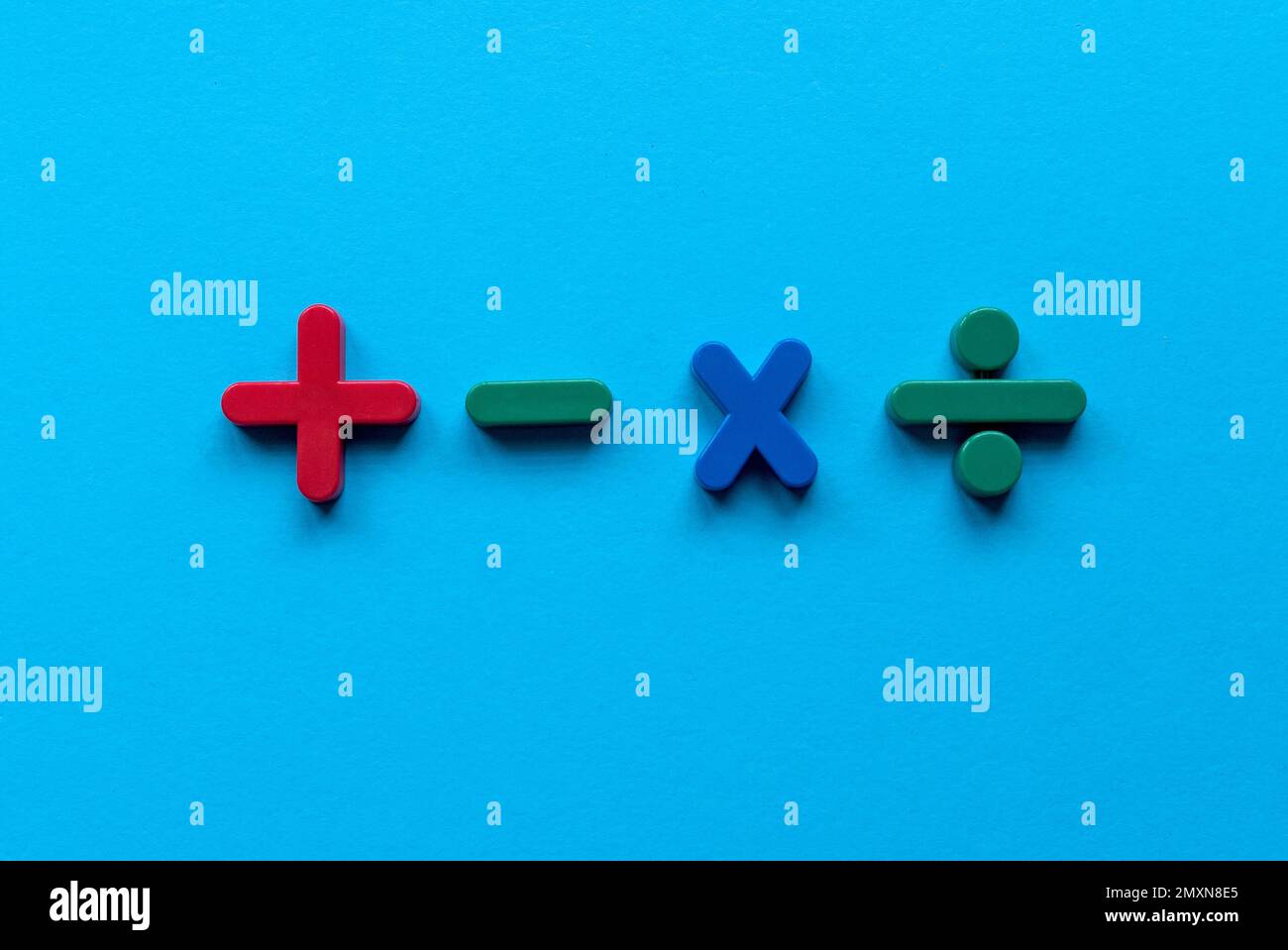 Farbige mathematische Form (Plus, Minus, Multiplizieren, Teilen) auf blauem Hintergrund. Stockfoto