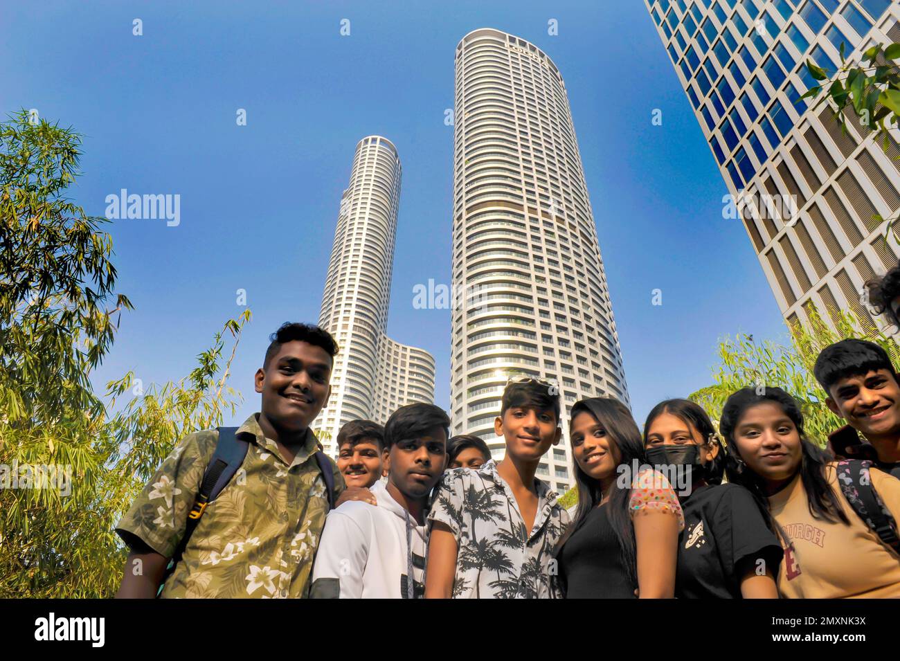 INDIEN. MUMBAI (BOMBAY) EINE GRUPPE VON TEENAGERN VOR DEN BÜROTÜRMEN DER LODHA WORLD TOWERS, SYMBOL DER NEUEN INDISCHEN WIRTSCHAFT Stockfoto