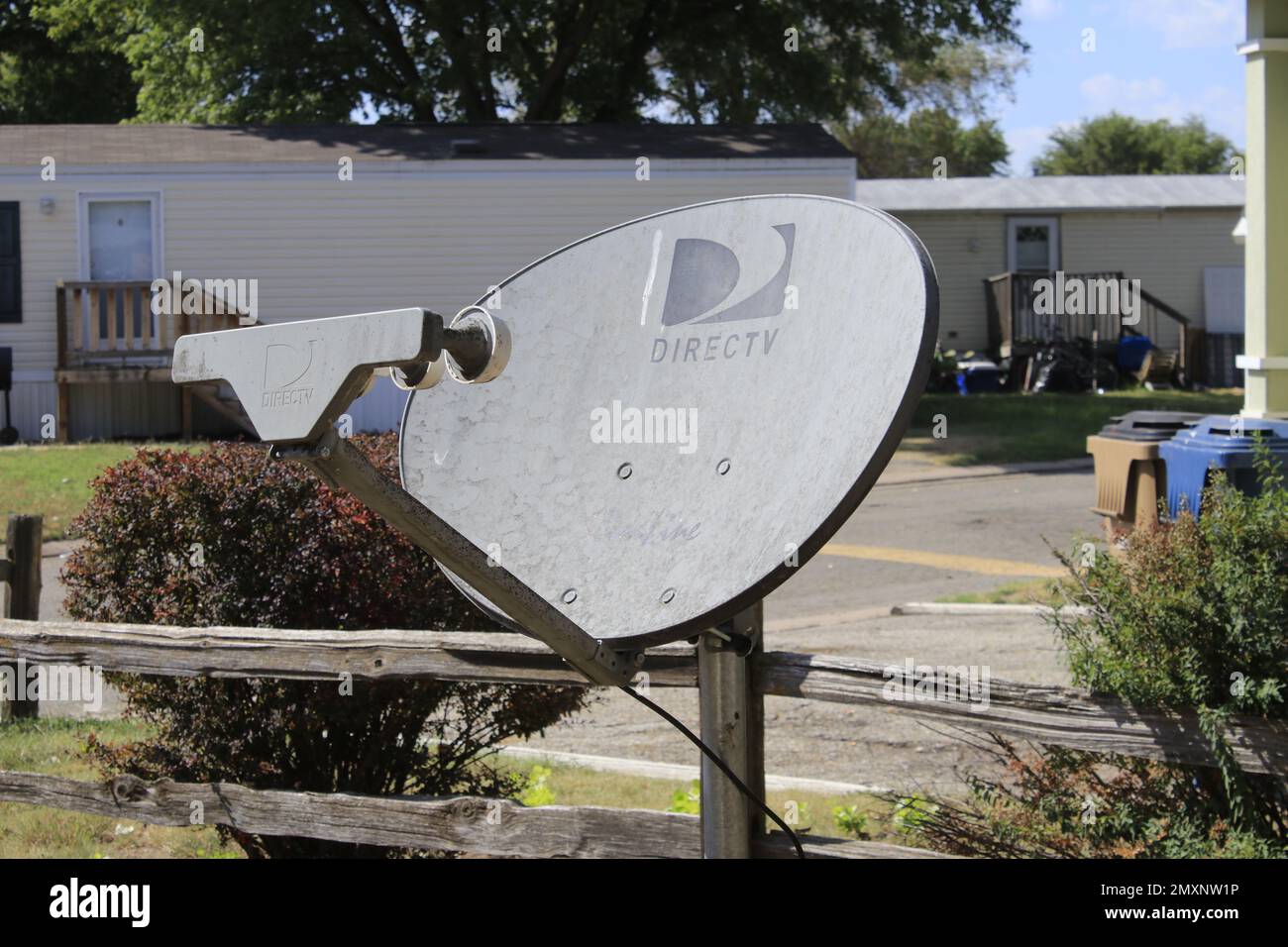 Direct TV Satellit in einem Hoffoto Nahaufnahme mit Bäumen im Hintergrund Stockfoto