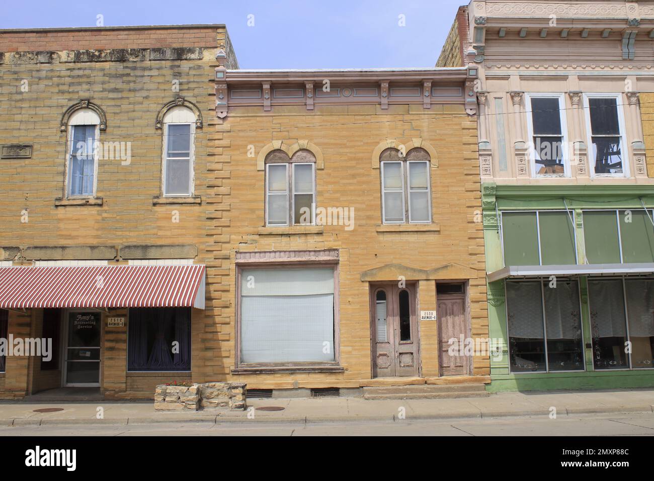 Alte Gebäude in Kansas mit blauem Himmel und Schaufenstern aus vergangenen Jahren Stockfoto