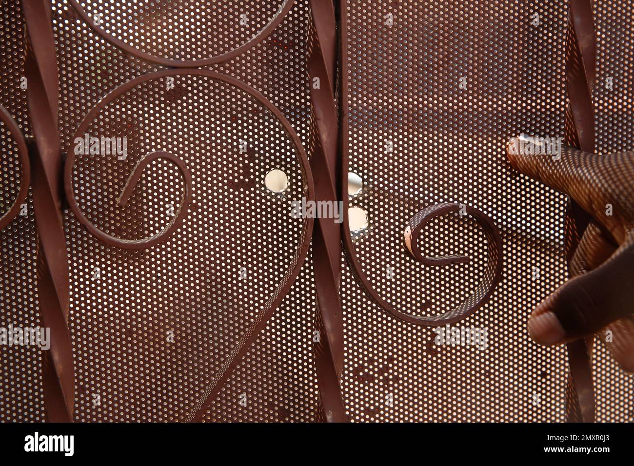 A neighbor shows a metal door pierced by bullet holes at the end of a driveway in Los Angeles on Sunday, Oct. 2, 2016. Officers shot and killed Carnell Snell Jr. in south Los Angeles on Saturday at the end of a car chase, sparking a protest by several dozen people angered by another fatal police shooting of a black man. (AP Photo/Damian Dovarganes) Stockfoto