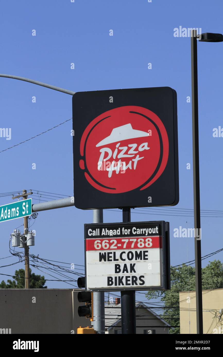 Ein Plakat von Pizza Hut auf einem Stab mit blauem Himmel Stockfoto