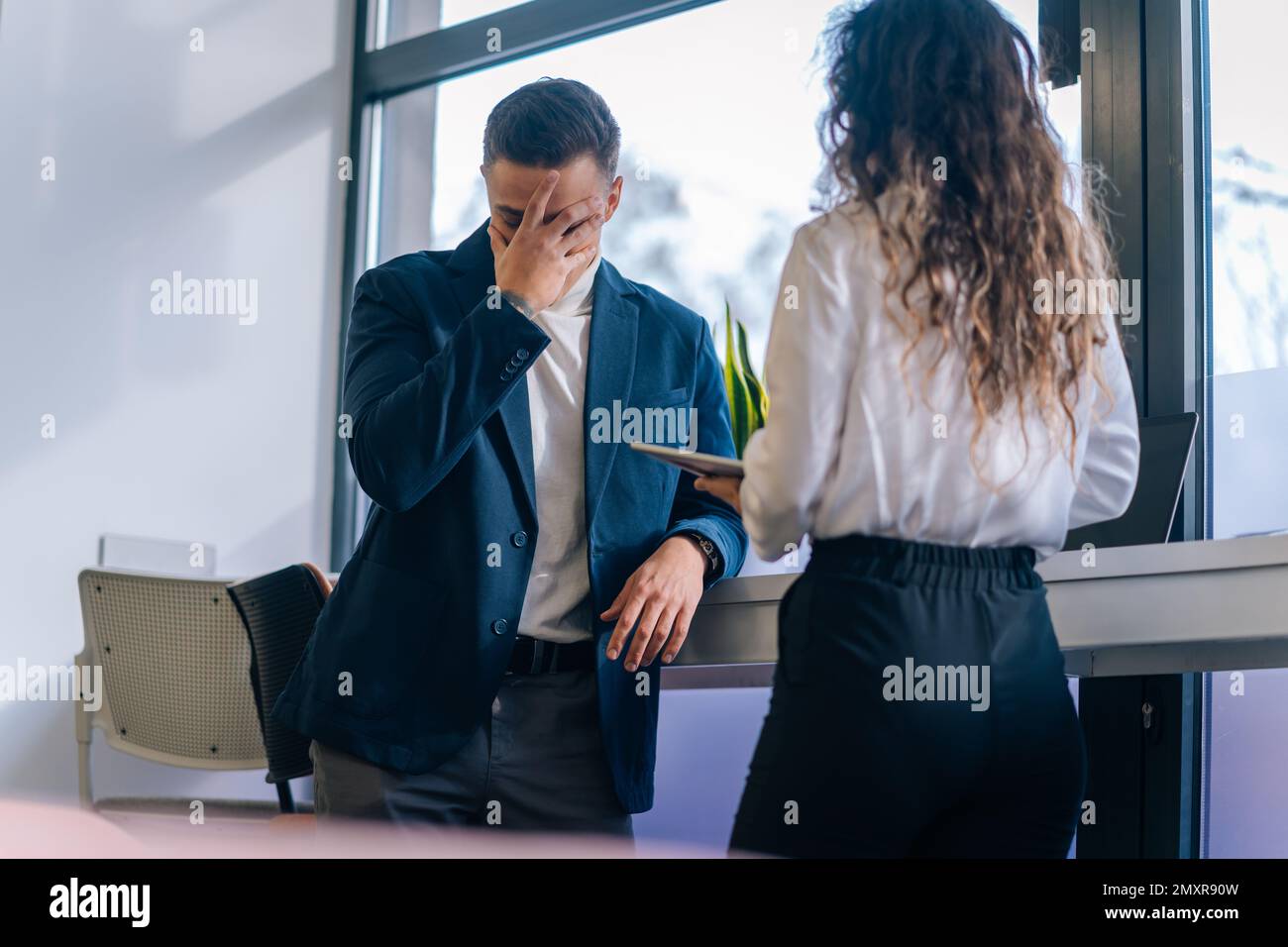 Ein gut aussehender Nachwuchsarbeiter hat einen großen Fehler gemacht. Er hat es gerade seinem Vorgesetzten gesagt. Es ist mir peinlich Stockfoto