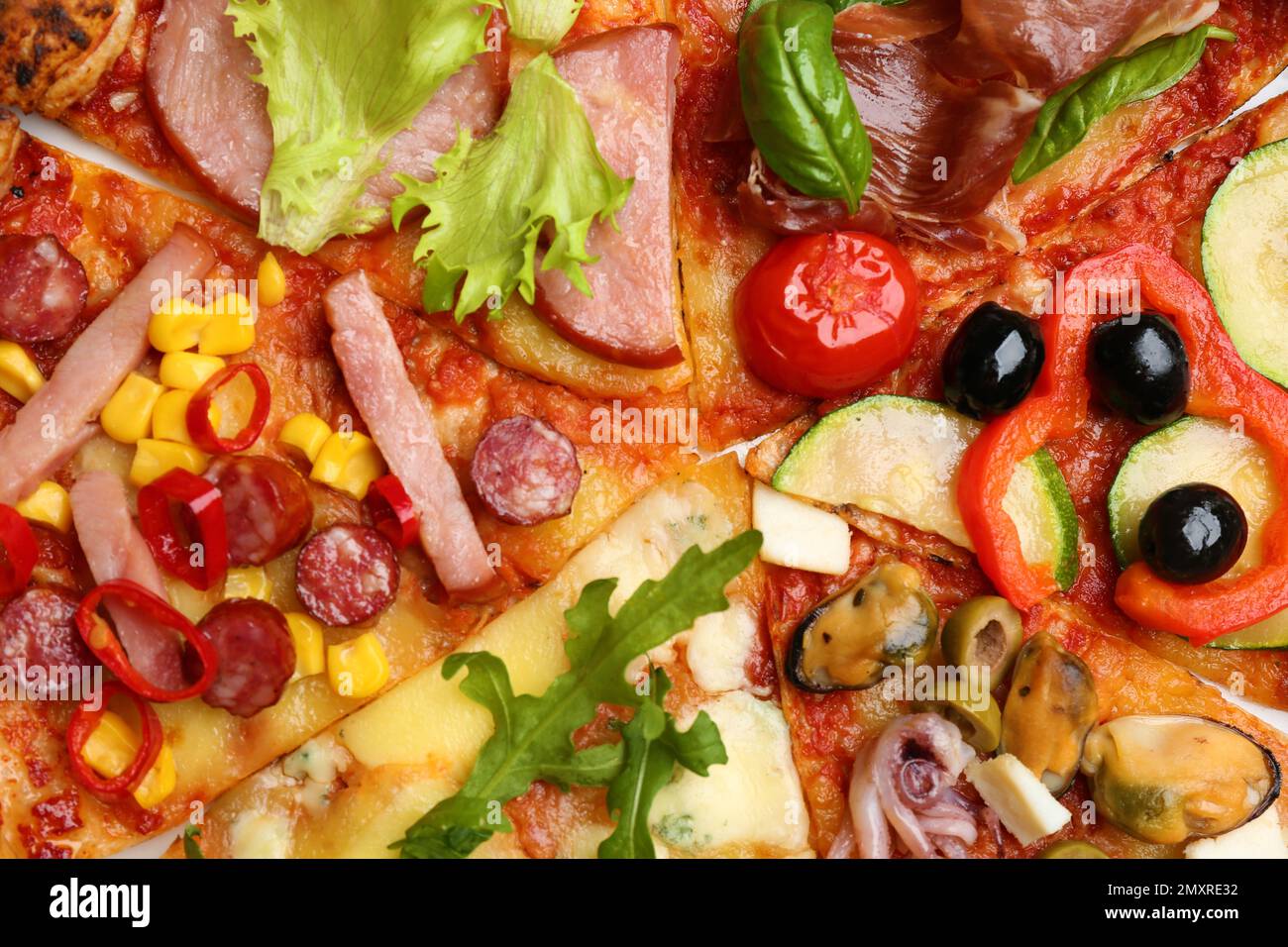 Scheiben von verschiedenen leckeren Pizzen als Hintergrund, Nahaufnahme Stockfoto