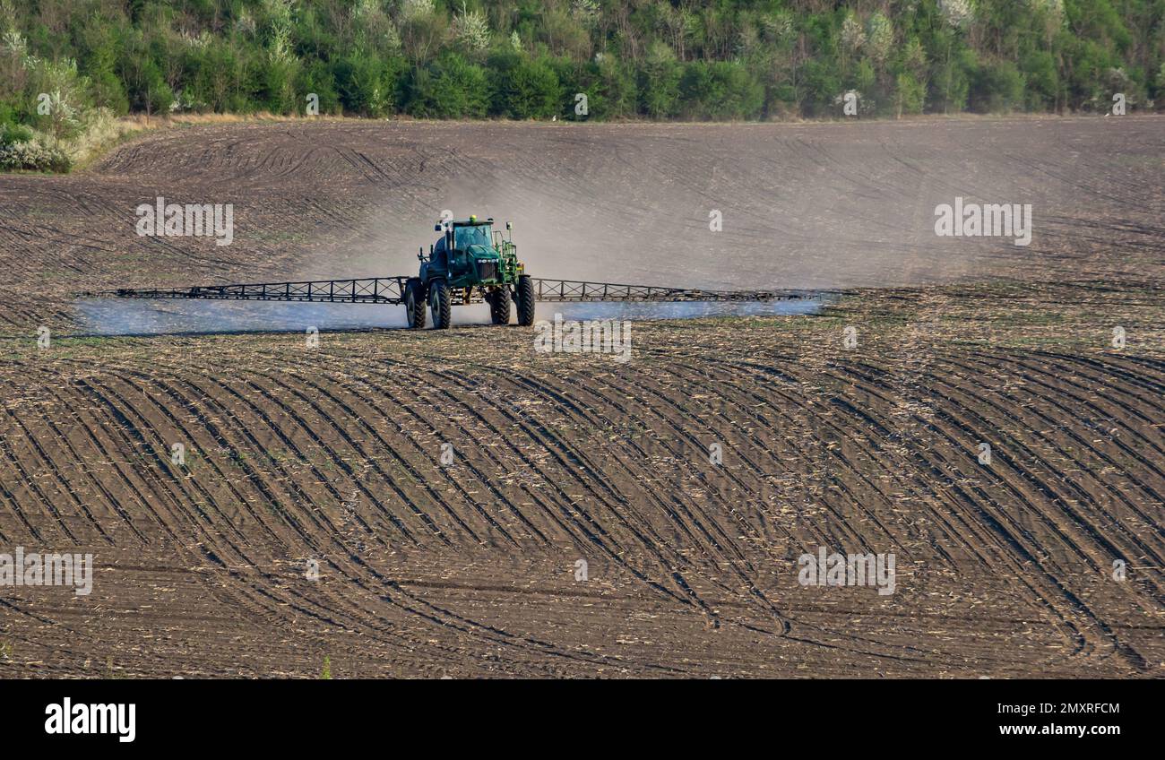 Traktor besprüht Pestizide auf Gemüsefeldern mit Feldspritze im Frühling. Stockfoto