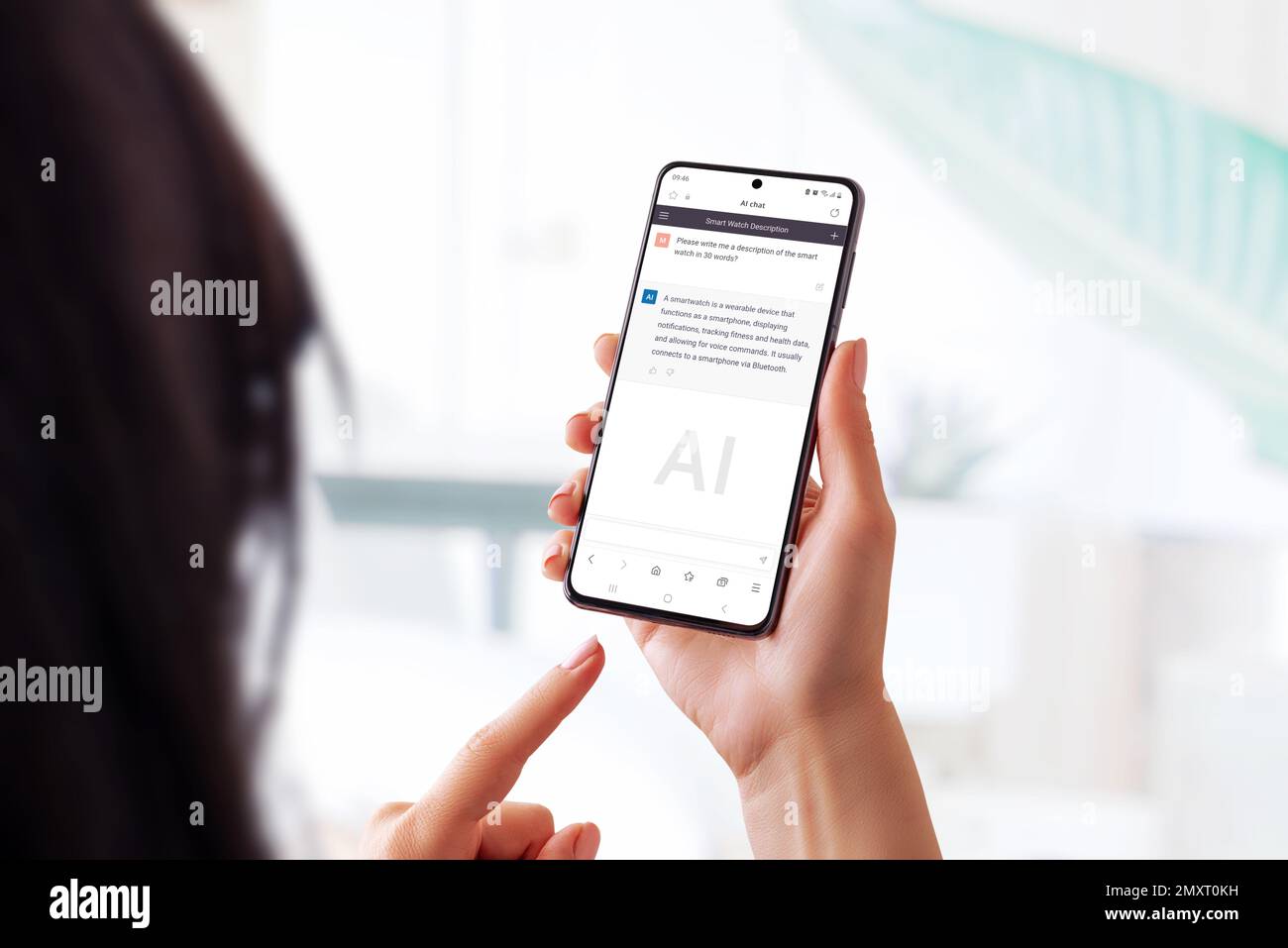 Frau, die ein Smartphone in der Hand hält und eine Chat-bot-App verwendet, um Fragen zu einer Smartwatch zu stellen. Zeigt die Verwendung von KI-Sprachmodellen für den Zugriff Stockfoto