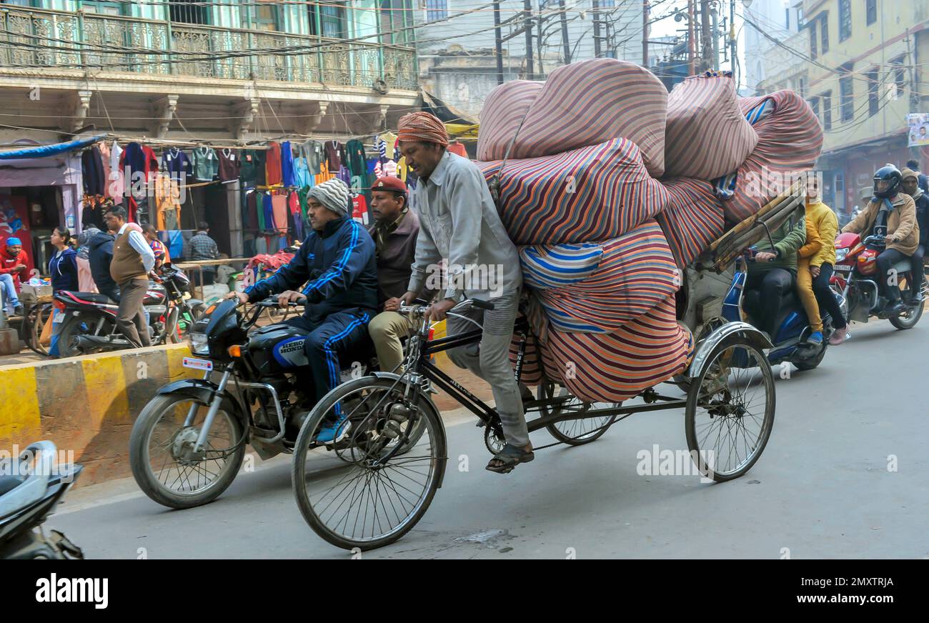 INDIEN. UTTARPRADESH. WARENTRANSPORT VARANASI (BENARES) DURCH RICK SHAW Stockfoto