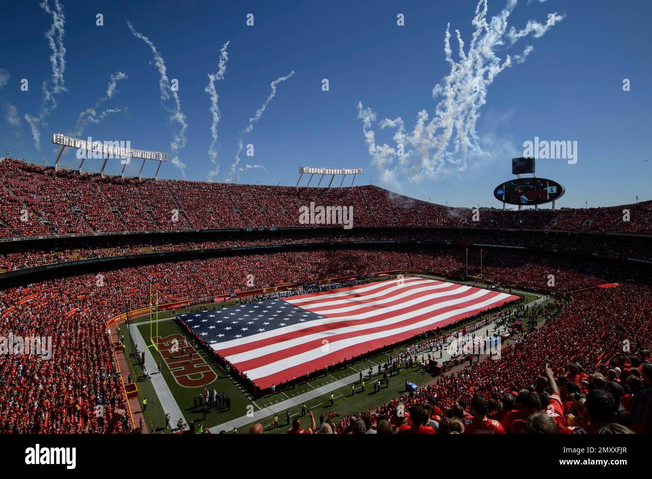 An American flag covers the Arrowhead Stadium field during fireworks before the start of an NFL game between the Kansas City Chiefs and the San Diego Chargers in Kansas City, Mo., Sunday, Sept. 11, 2016. (AP Photo/Reed Hoffmann) Stockfoto