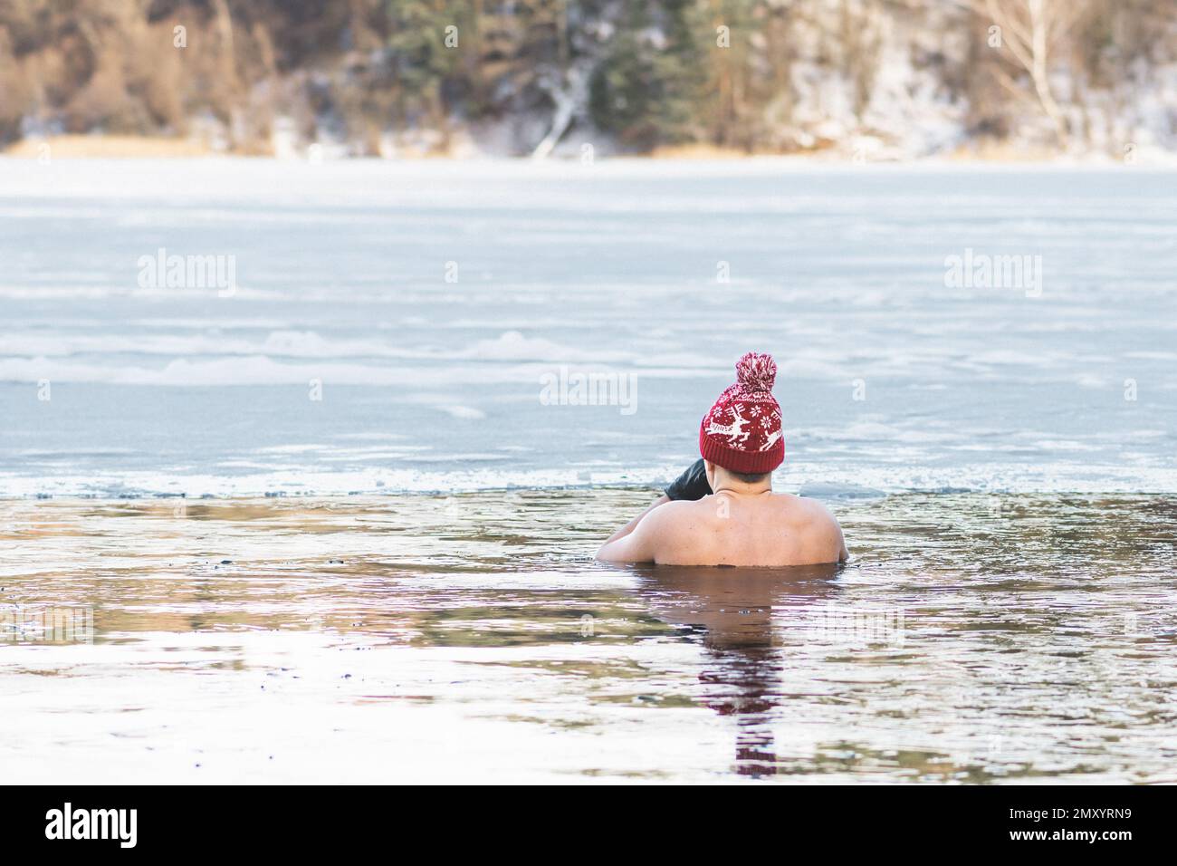 Hübscher Junge oder Mann, der im kalten Wasser eines Sees badet. Wim-Hof-Methode, Kältetherapie, Atemtechniken, Yoga und Meditation Stockfoto