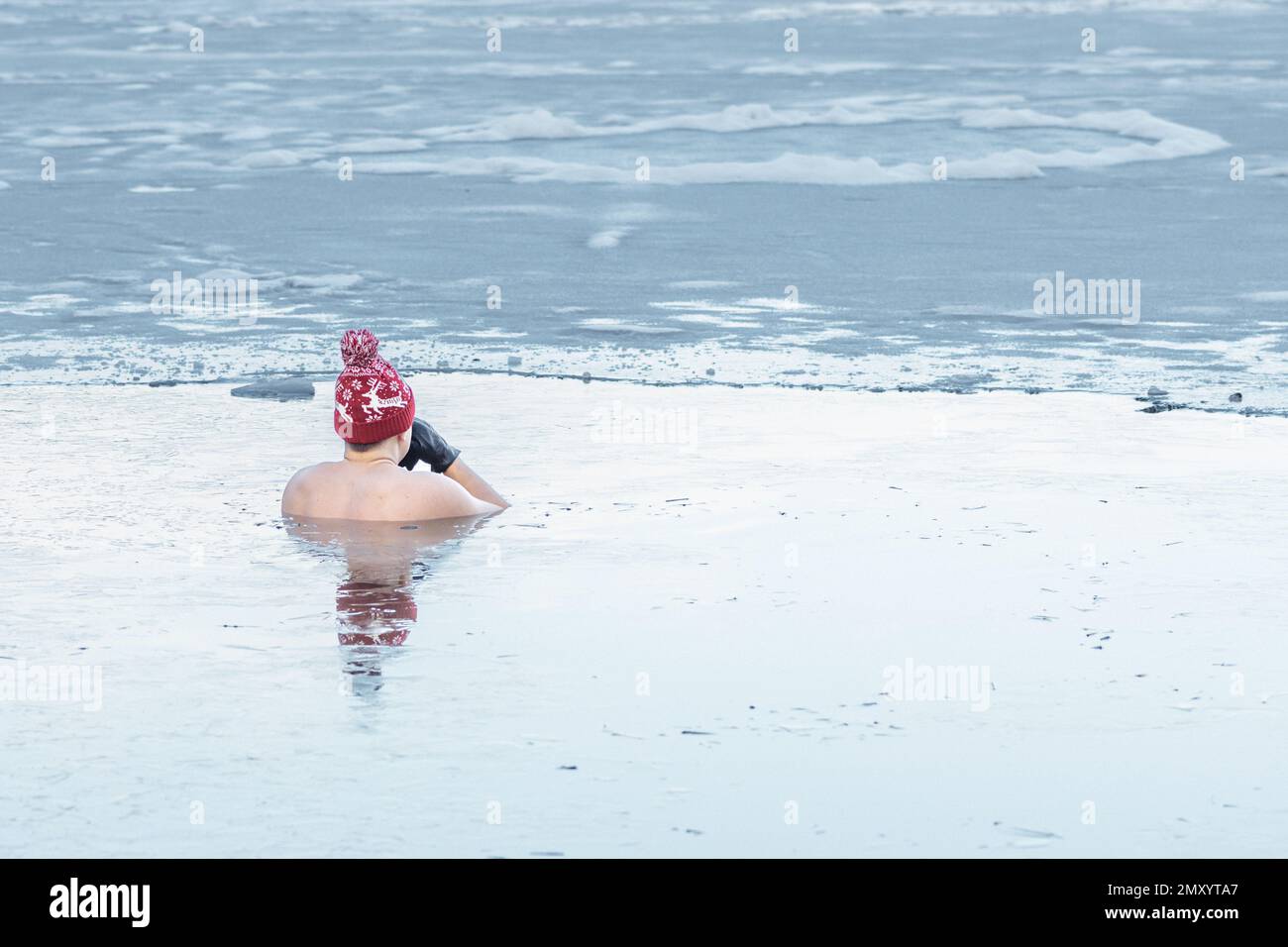 Hübscher Junge oder Mann, der im kalten Wasser eines Sees badet. WimHofMethode, Kältetherapie