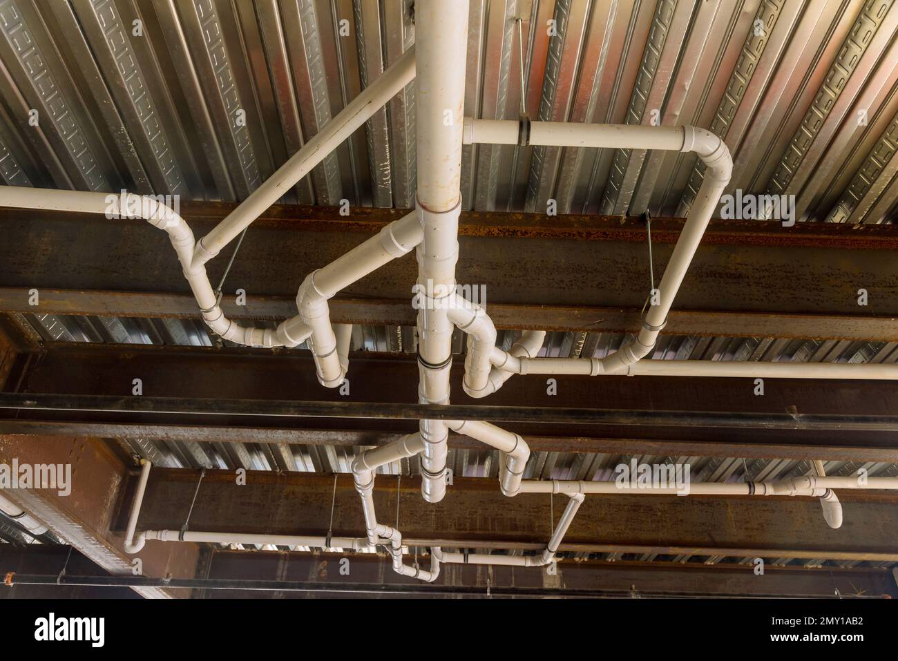 Installation von montierten Abflussleitungen unter der Decke eines Gebäudekomplexes Stockfoto