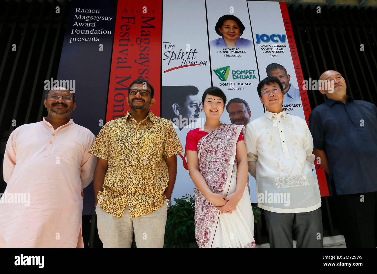 The Ramon Magsaysay awardees for this year pose by the tarpaulin poster following a news conference in Manila, Philippines. Saturday, Aug. 27, 2016. The Ramon Magsaysay Awards, Asia's equivalent of the Nobel Prize, is given annually in honor of the the late Philippine President who died in a plane crash, and awarded to persons "who address issues of human development in Asia with courage and creativity, and in doing so have made contributions that have transformed their societies for the better." They are, from left, Bezwada Wilson from India, Thodur Madabusi Krishna, also from India, Japan Ov Stockfoto