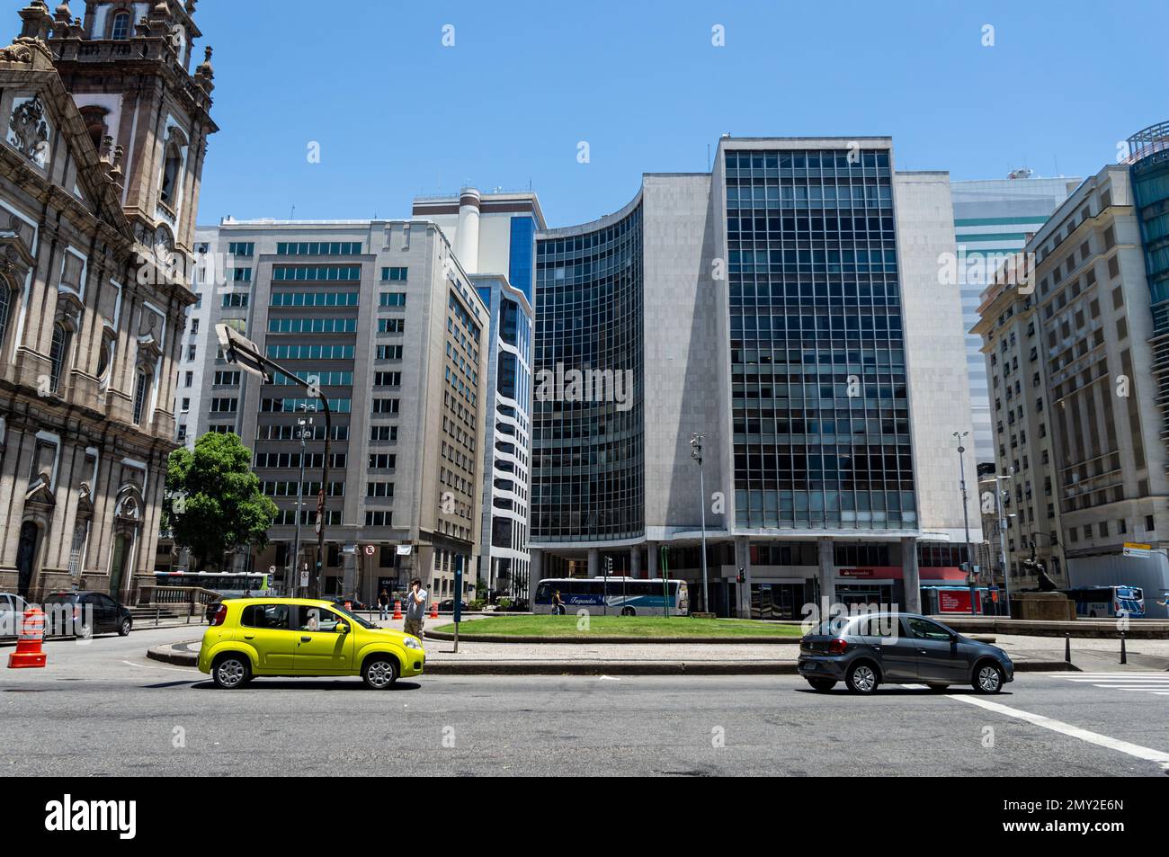 Blick auf die nahe gelegenen Geschäftsgebäude am Barao de Drumond Platz und die Candelaria Kirche im Centro Viertel unter dem sonnigen, klaren blauen Himmel. Stockfoto