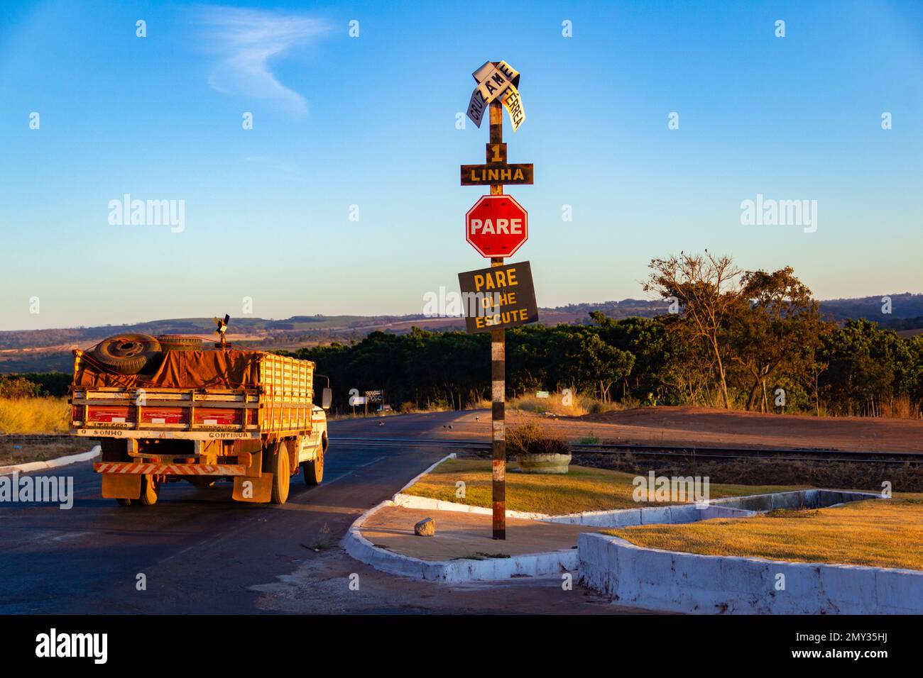 Goiania, Goias, Brasilien – 10. Juli 2022: Ein Lkw, der durch den Bahnübergang in der Stadt Bonfinópolis in Goiás fährt und mit eingebeulten Schildern versehen ist. Stockfoto
