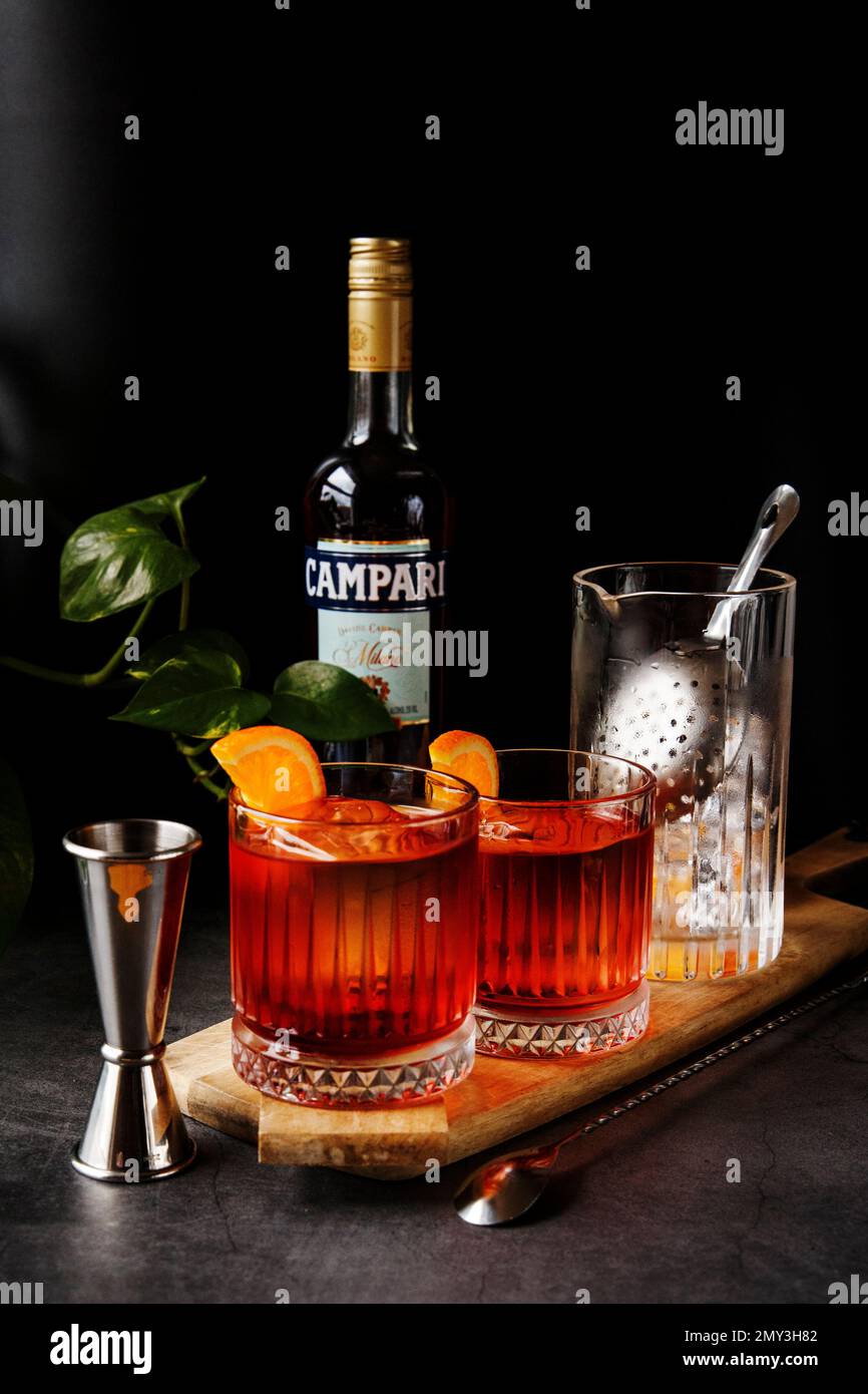 Negroni Cocktail-Getränk auf schwarzem Hintergrund und Barkeeper-Werkzeuge. Stockfoto
