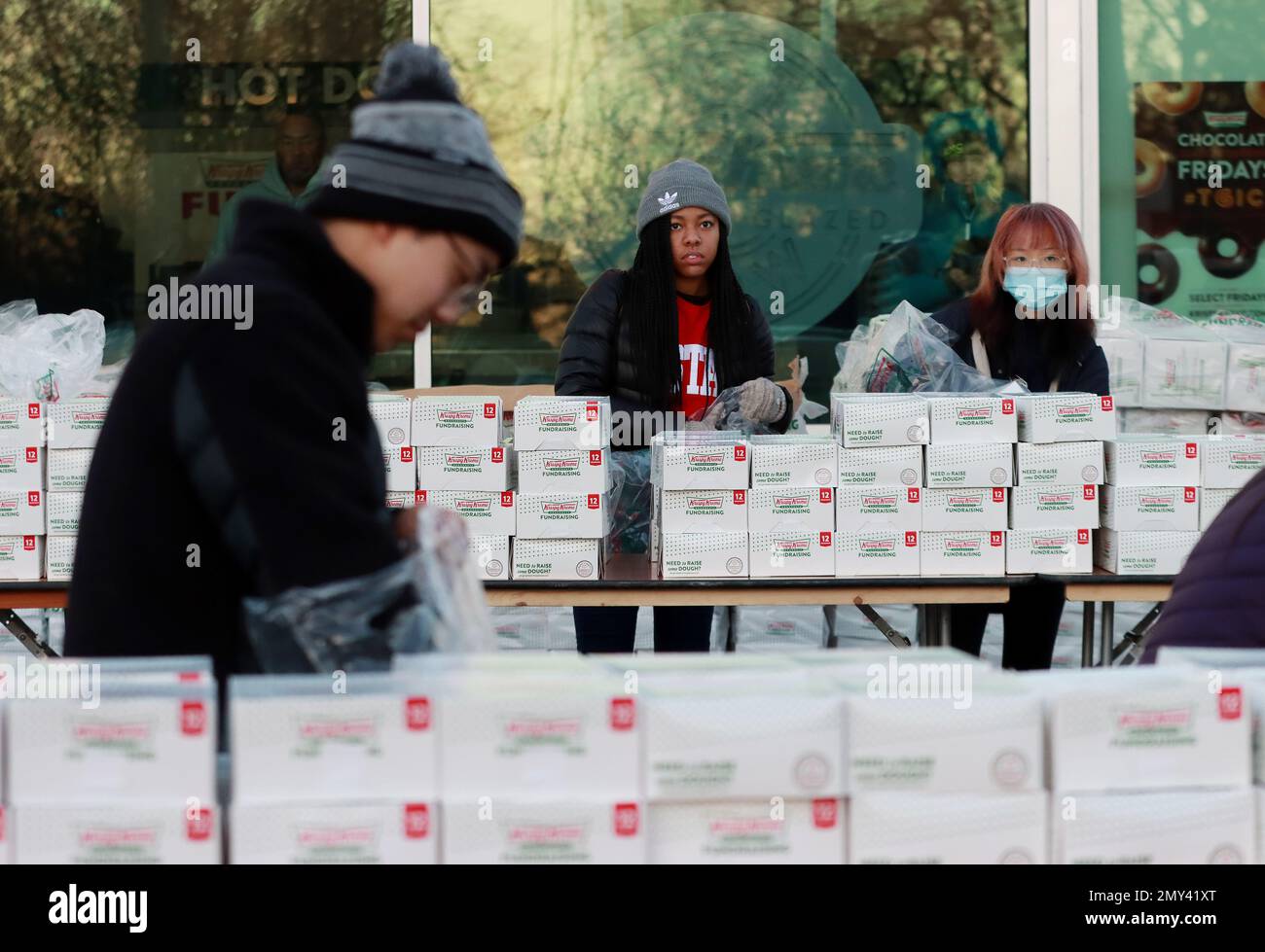 Raleigh, North Carolina, USA. 4. Februar 2023. Freiwillige bereiten sich auf über 4000 Läufer vor, die 19. die Straße erobern, bei der alljährlichen Krispy Kreme Challenge, einem Schülerrennen für wohltätige Zwecke im UNC Children's Hospital. Die Teilnehmer beginnen auf dem Campus von North Carolina State, wo sie 2,5 km bis zum berühmten Krispy Kreme Store von Raleigh laufen, ein Dutzend original glasierte Donuts konsumieren und 2,5 km zurück zum Campus von NC State laufen. (Kreditbild: © Bob Karp/ZUMA Press Wire) NUR REDAKTIONELLE VERWENDUNG! Nicht für den kommerziellen GEBRAUCH! Stockfoto