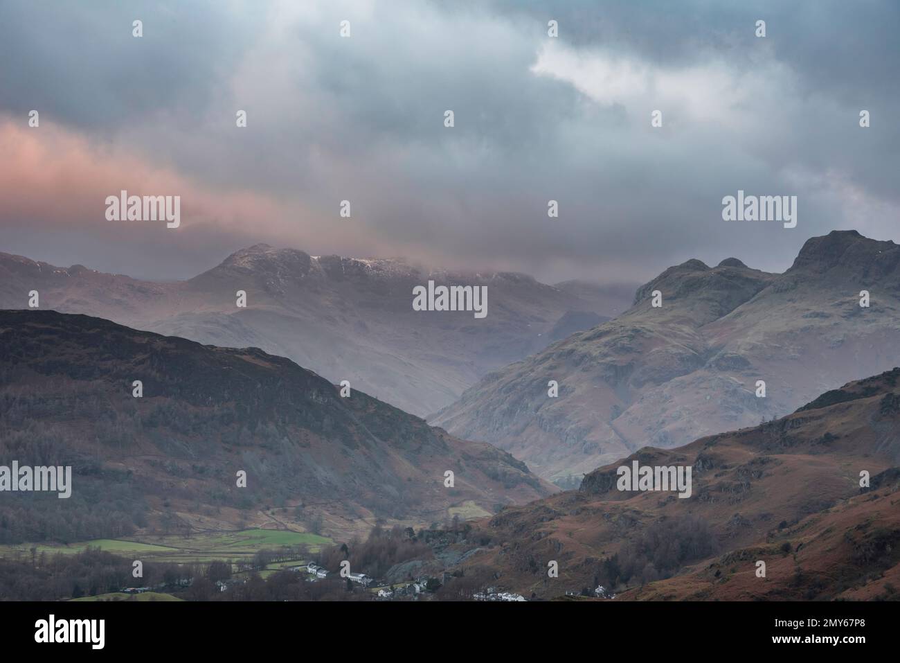 Wunderschöne Winterlandschaft mit Sonnenaufgang von Loughrigg über die Landschaft in Richtung Langdale Pikes und Pike O'Blisco im Lake District Stockfoto