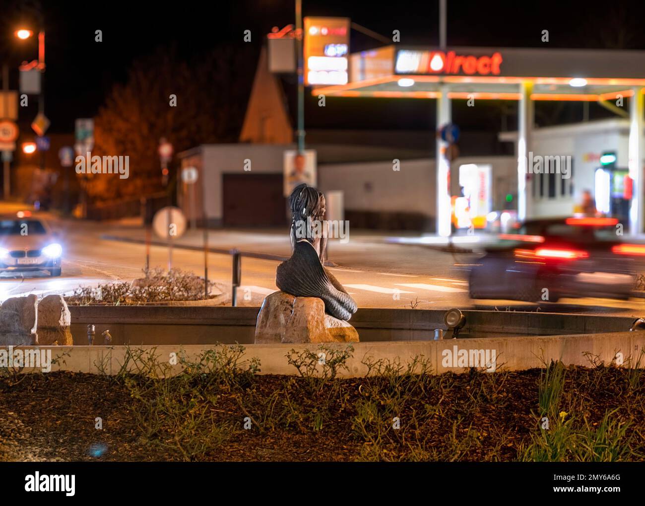 Kreisverkehr mit Statue einer Donaujungfrau bei Nacht in der Kleinstadt Tulln, Österreich Stockfoto
