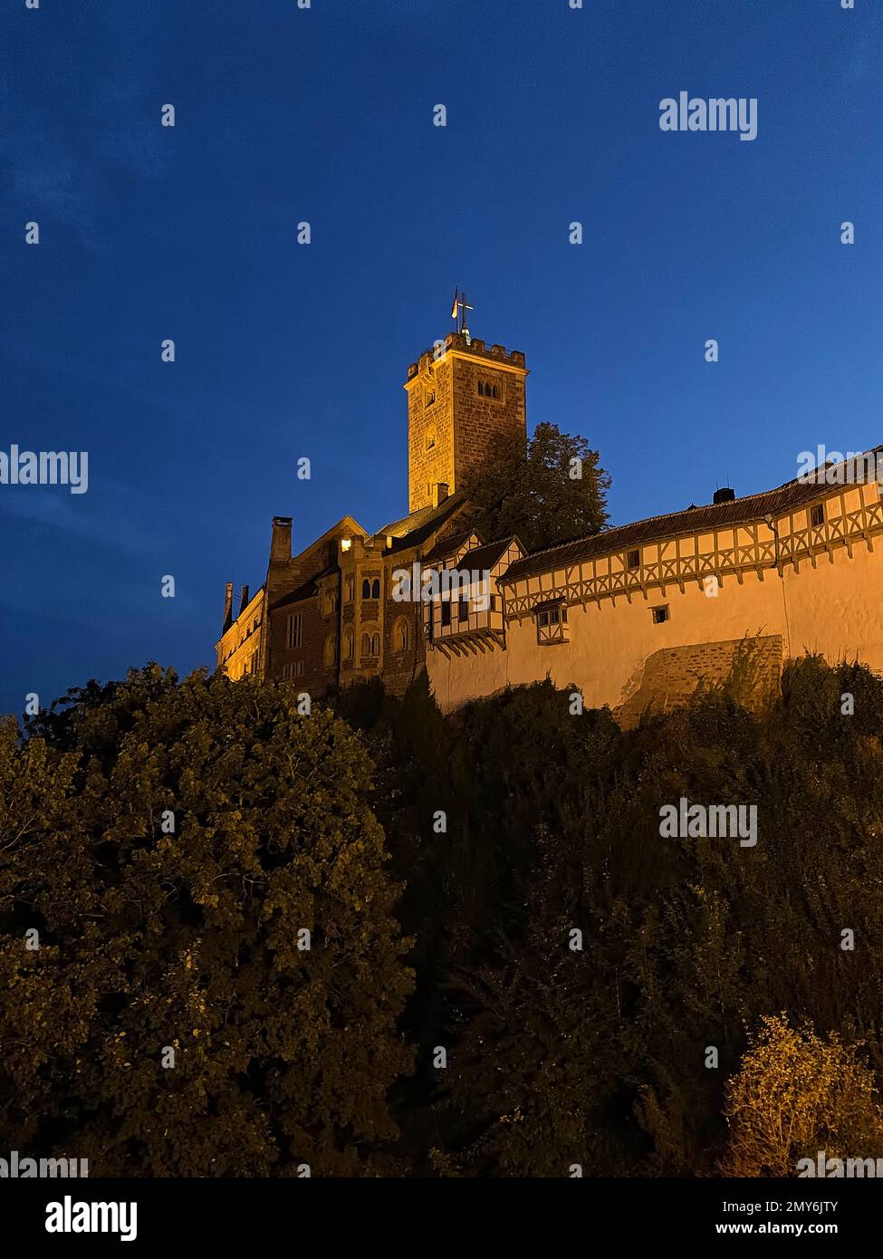 Eisenach, Deutschland - 09 06 2021: Das alte deutsche Wartburg Eisenach, das nachts beleuchtet wurde und hoch über der Altstadt ragt, war die Zuflucht des P. Stockfoto