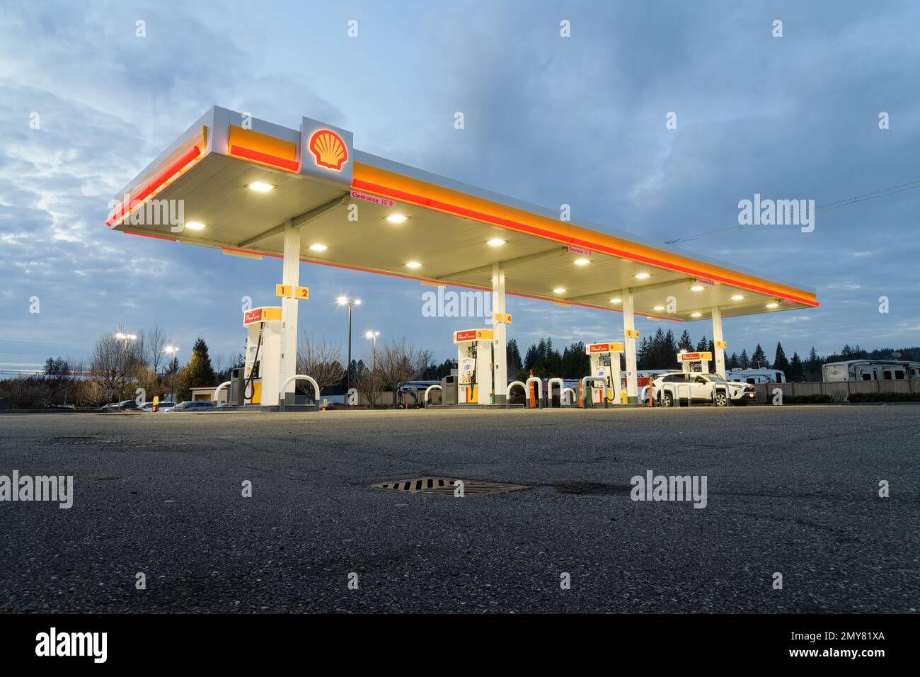 Sultan, WA, USA - 01. Februar 2023; Shell-Tankstellenpumpen mit beleuchteter Markise und Schild Stockfoto