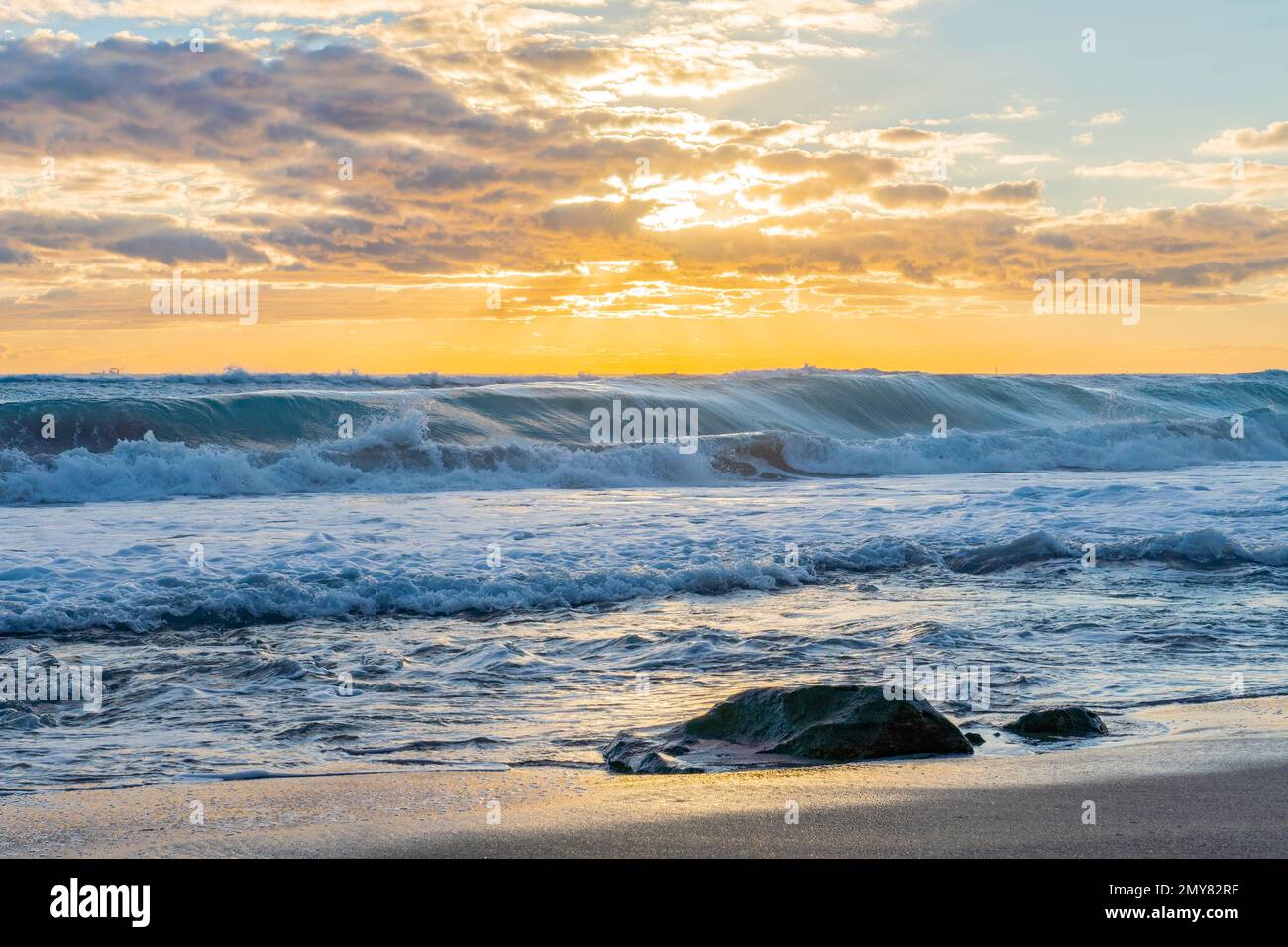Wellen aus dem Atlantik stürzen bei Sonnenaufgang auf den versteinerten Korallenfelsen von Singer Island Florida ab Stockfoto