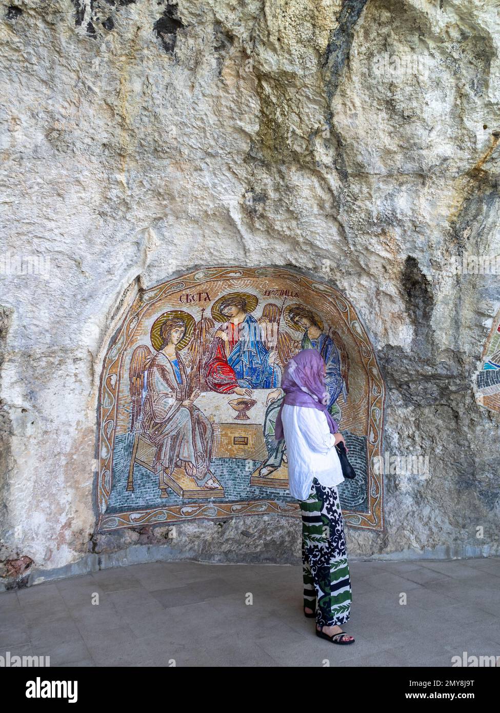 Eine Frau mit einem Mosaik, die Engel in der oberen Kirche des Ostrog-Klosters darstellt Stockfoto